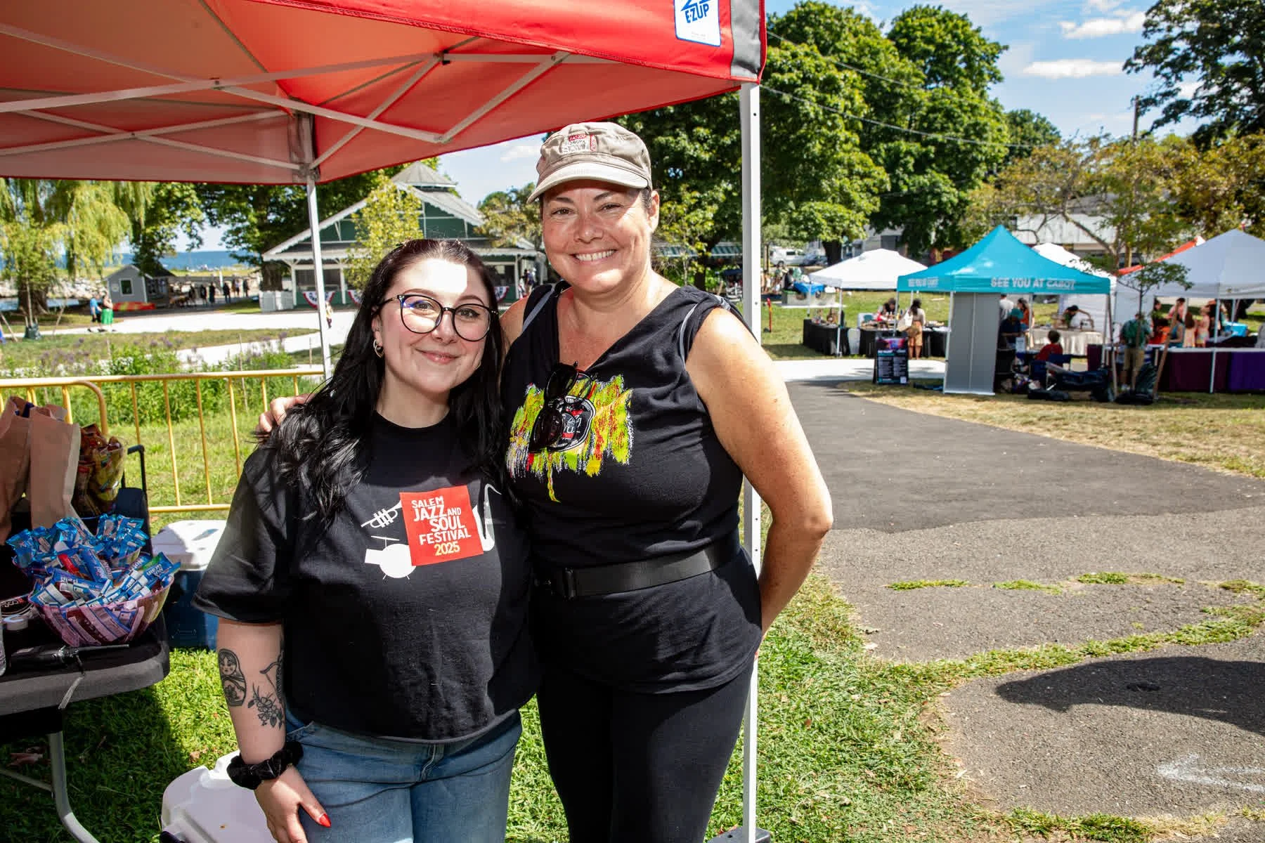 Two Salem Jazz and Soul Festival volunteers smile near the local maker marketplace at Salem Willows.