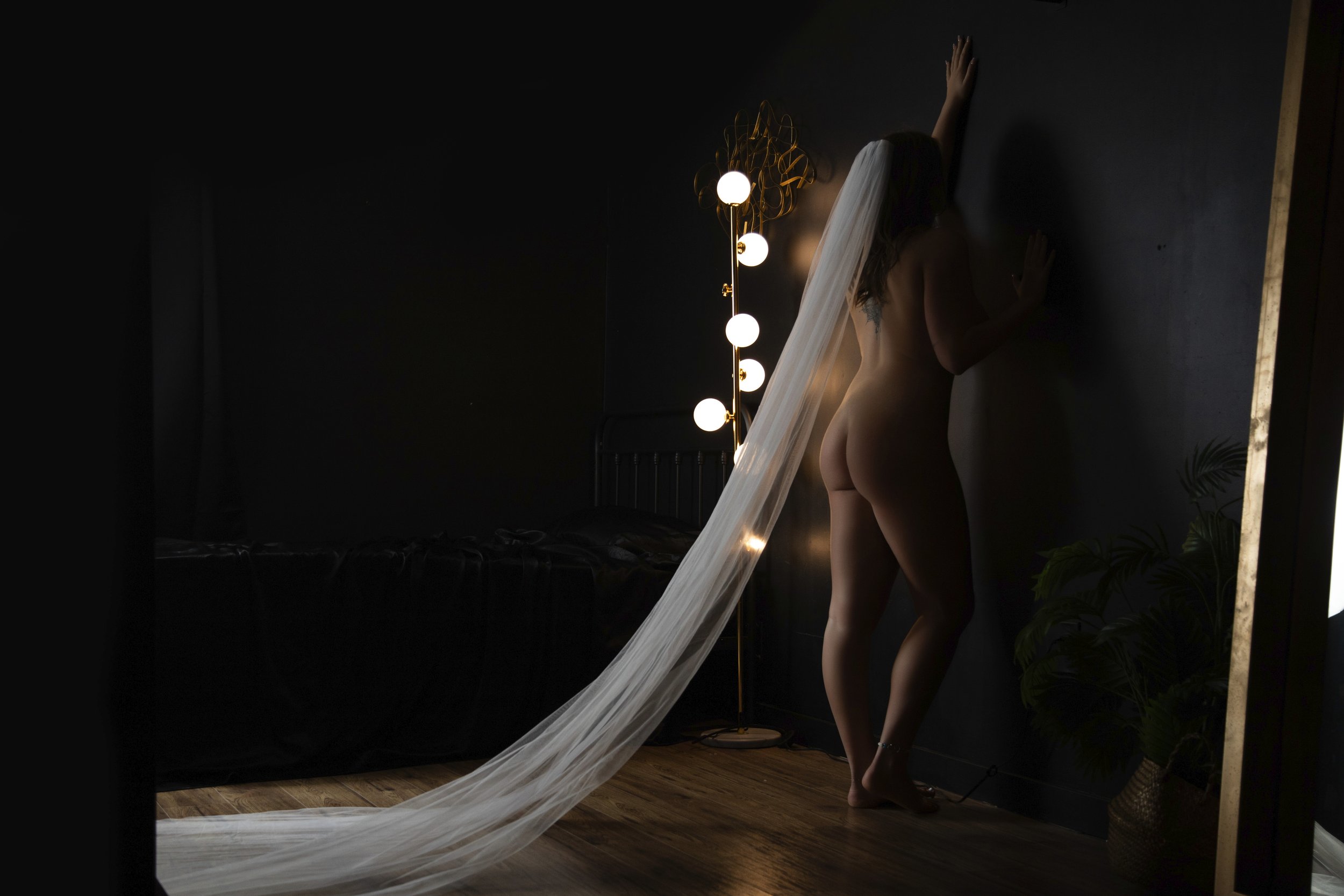 Calgary Couples Boudoir Photographer - a beautiful woman and her husband in a sexy dark boudoir studio