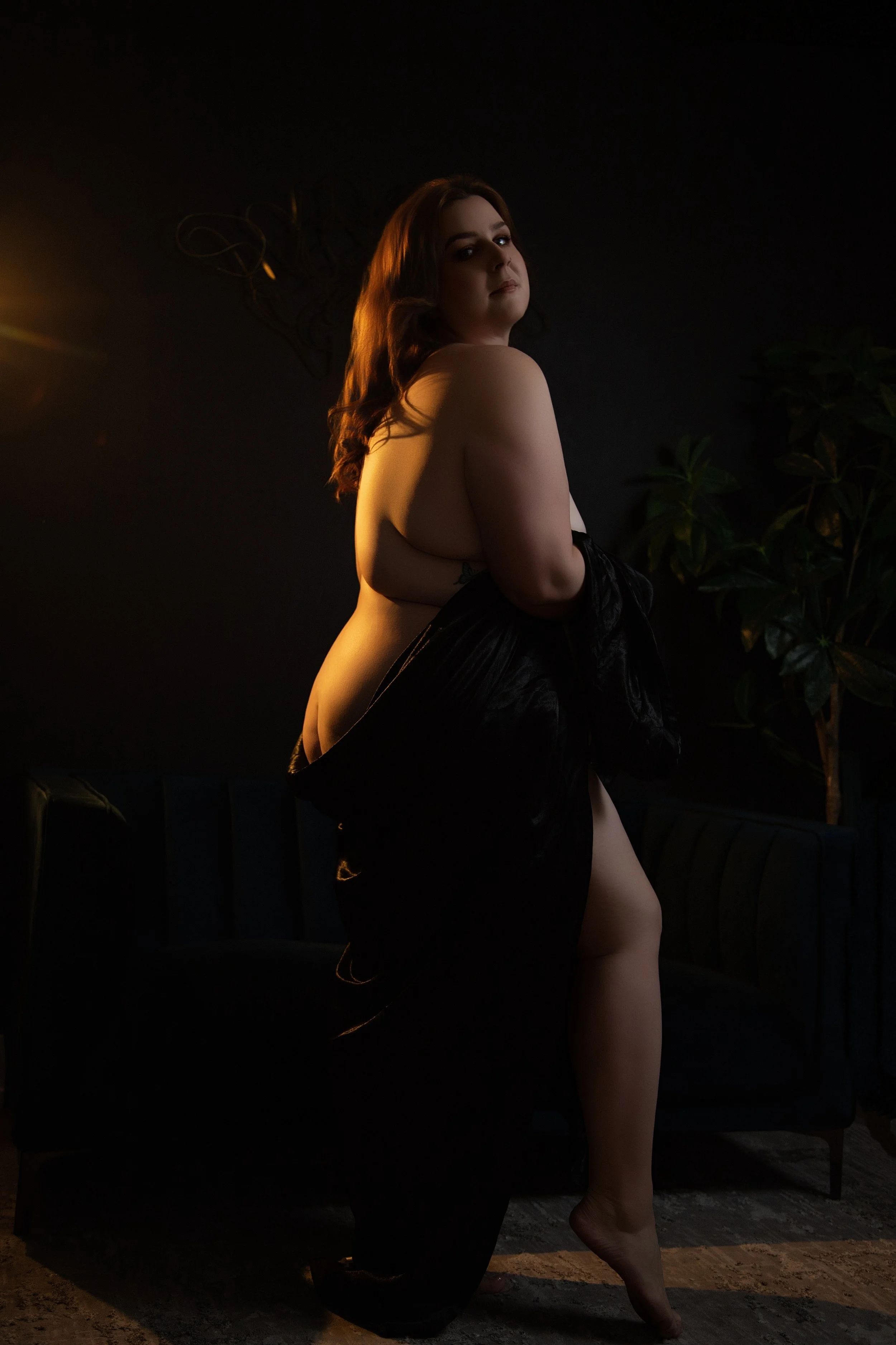 Plus sized woman in a sheet in a boudoir studio in calgary alberta