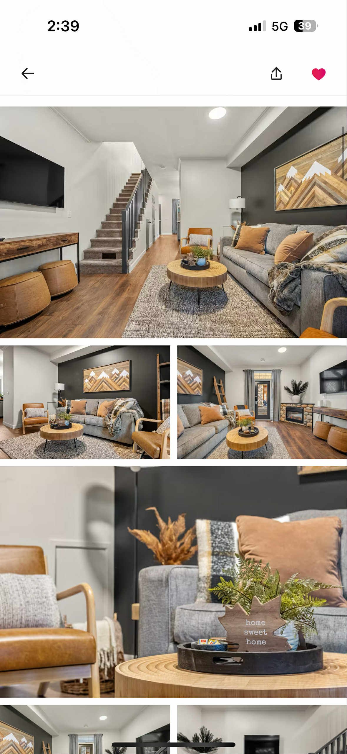 Living room with a gray sofa, orange pillows, wooden coffee table, wall art, fireplace, and various seating options in a modern, cozy style.