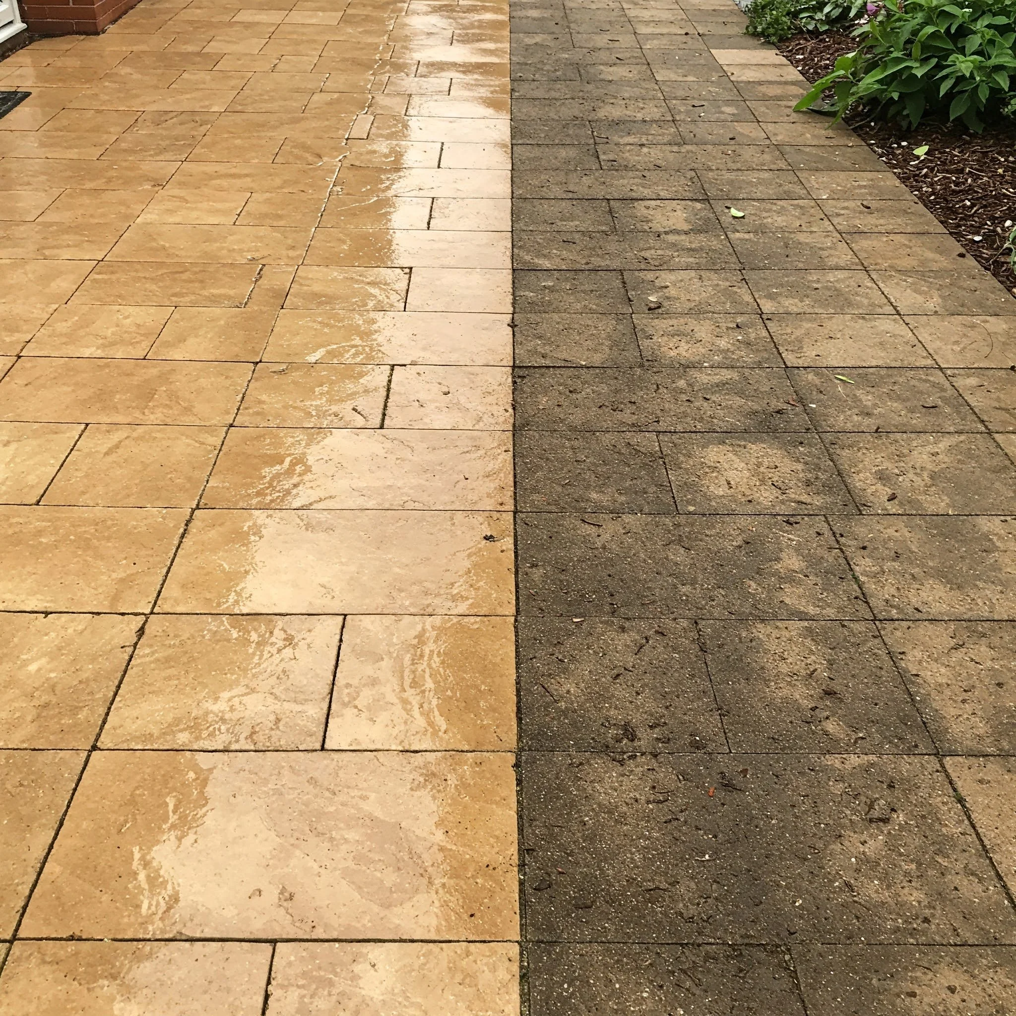The image shows a side-by-side comparison of two different types of outdoor paving. On the left, there are wet, light-colored tiles with a glossy surface, and on the right, dry, darker tiles with a matte finish. There are some green plants visible in the top right corner.