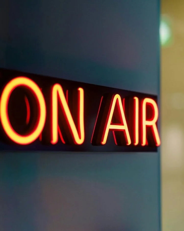Image of an orange on air sign on a grey wall.