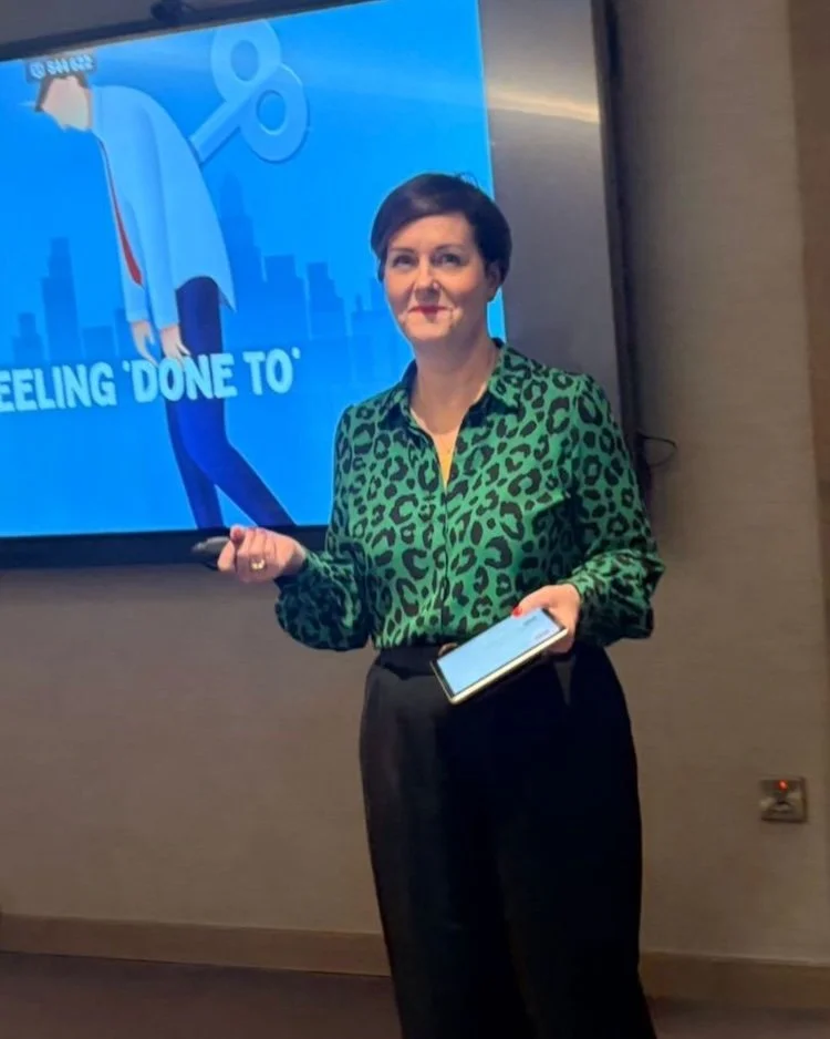 Sharon Smith in a green top and black trousers, leading a presentation on Self Leadership for Share.
