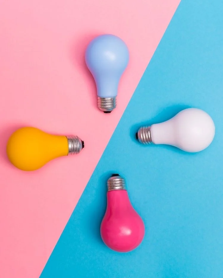 blue,light pink, dark pink and orange light bulbs on a pink and blue background. To represent a clearer way of thinking as a result of the Not winging it leadership club.