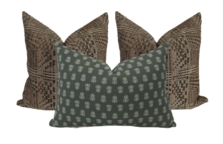 Three decorative throw pillows, two with a multicolored plaid pattern and one with a dark background and white floral design, arranged against a plain white background.