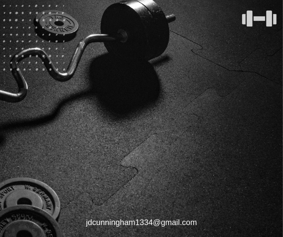 A barbells, weight plates, and small weights on a black gym floor.