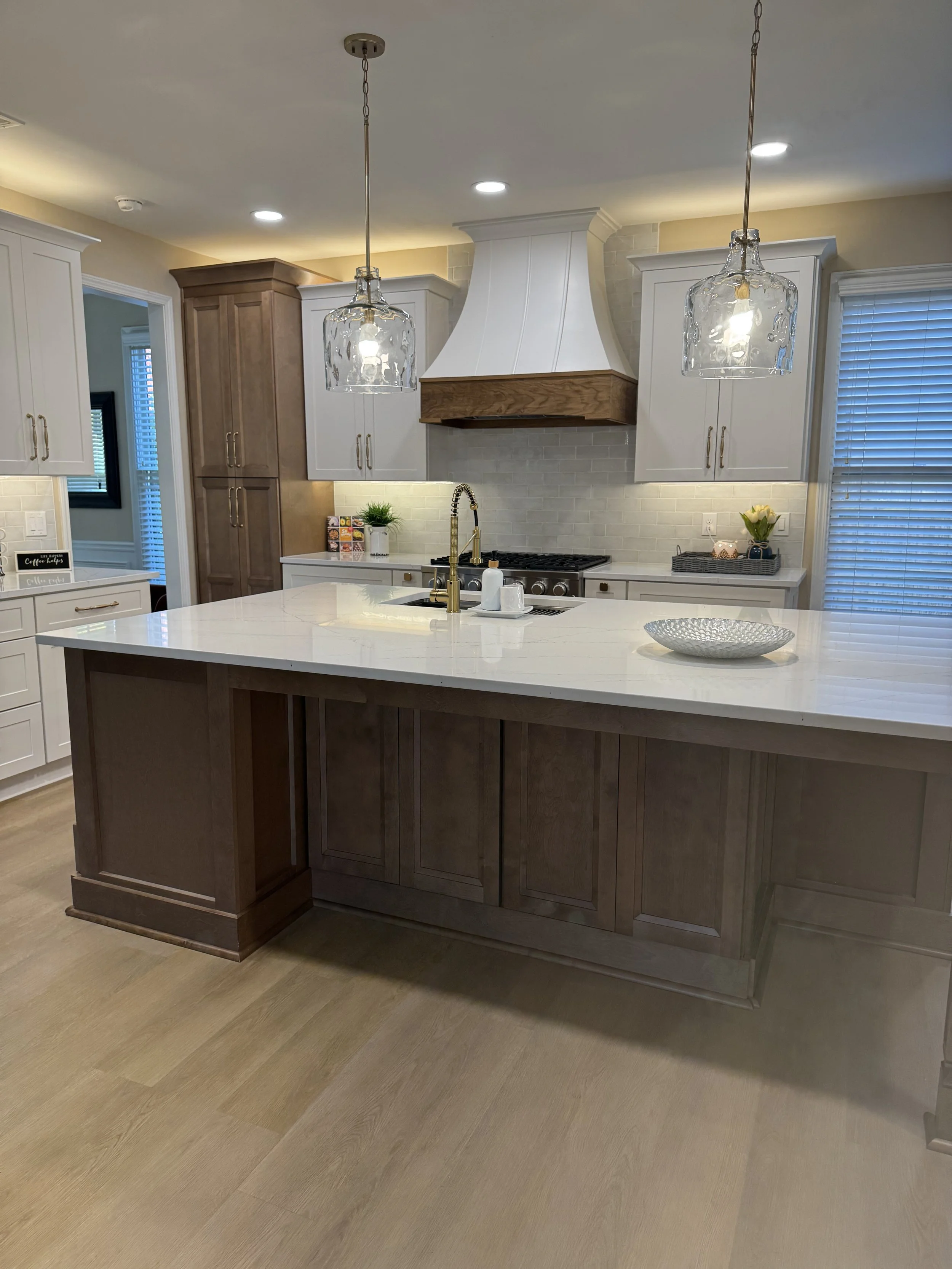 Modern kitchen remodel with light quartz, dark wood, and gold accents