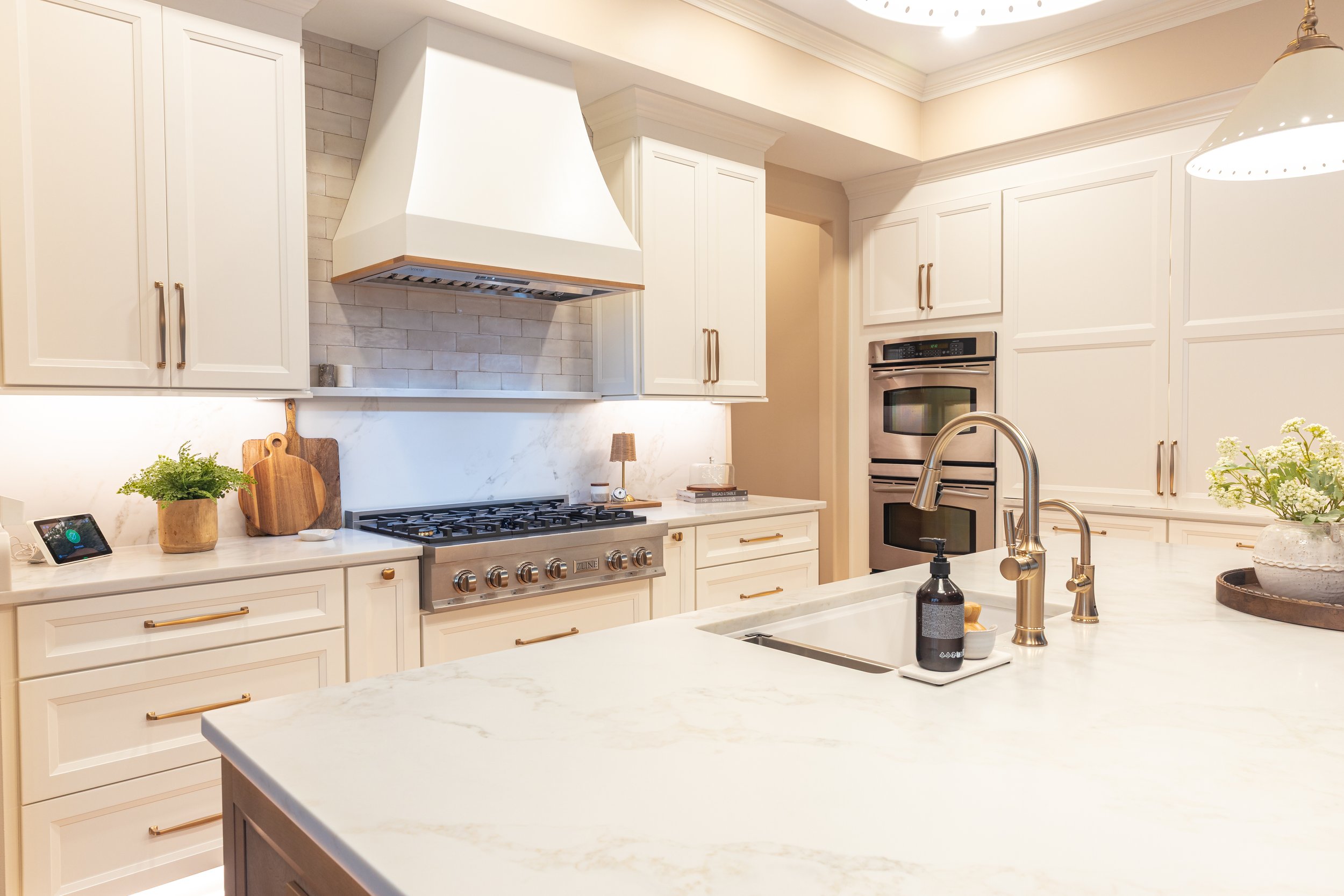 Luxury designed kitchen with white cabinets and gold accents