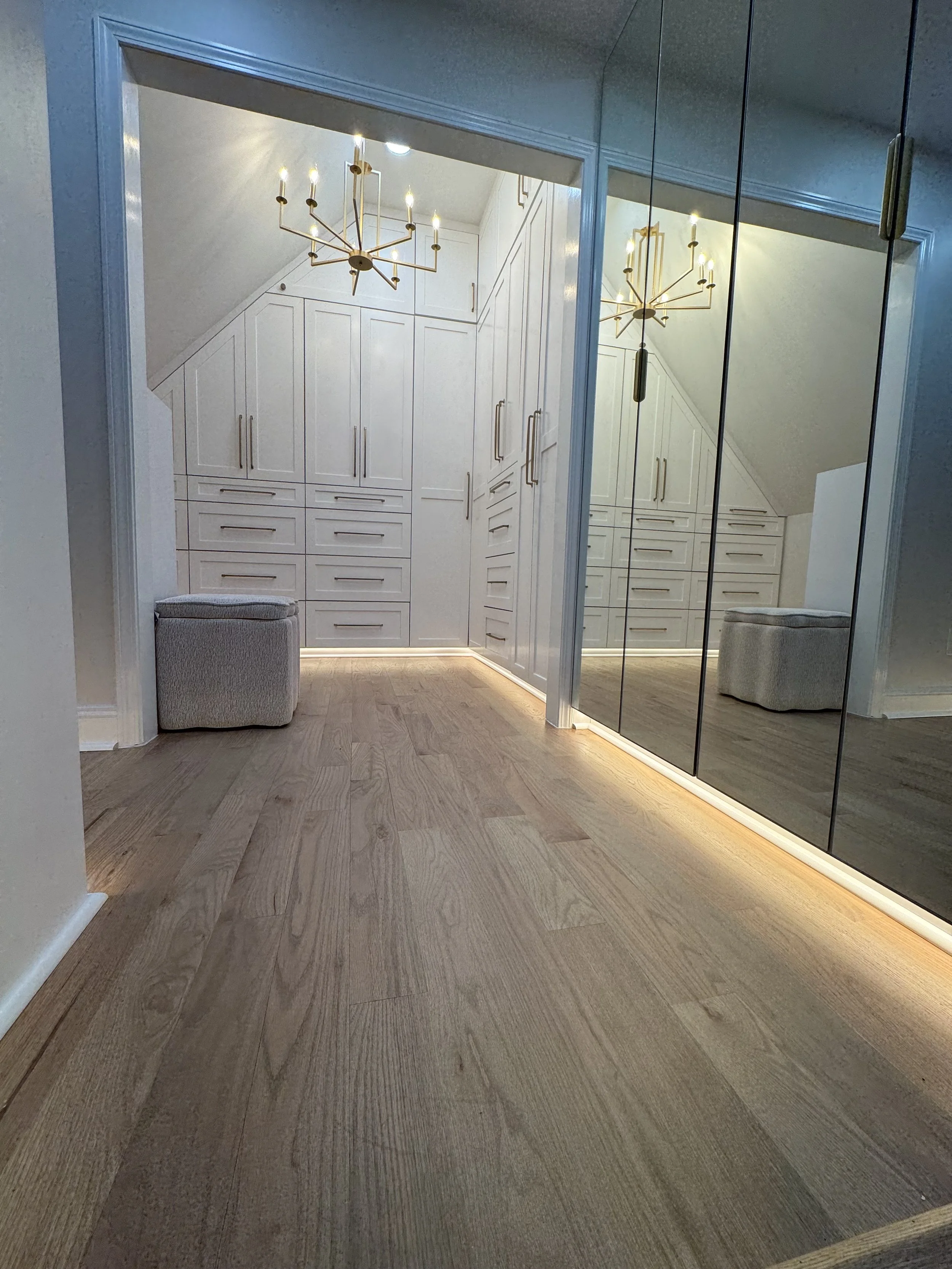Remodeled closet with intelligent storage and gold chandelier in Atlanta