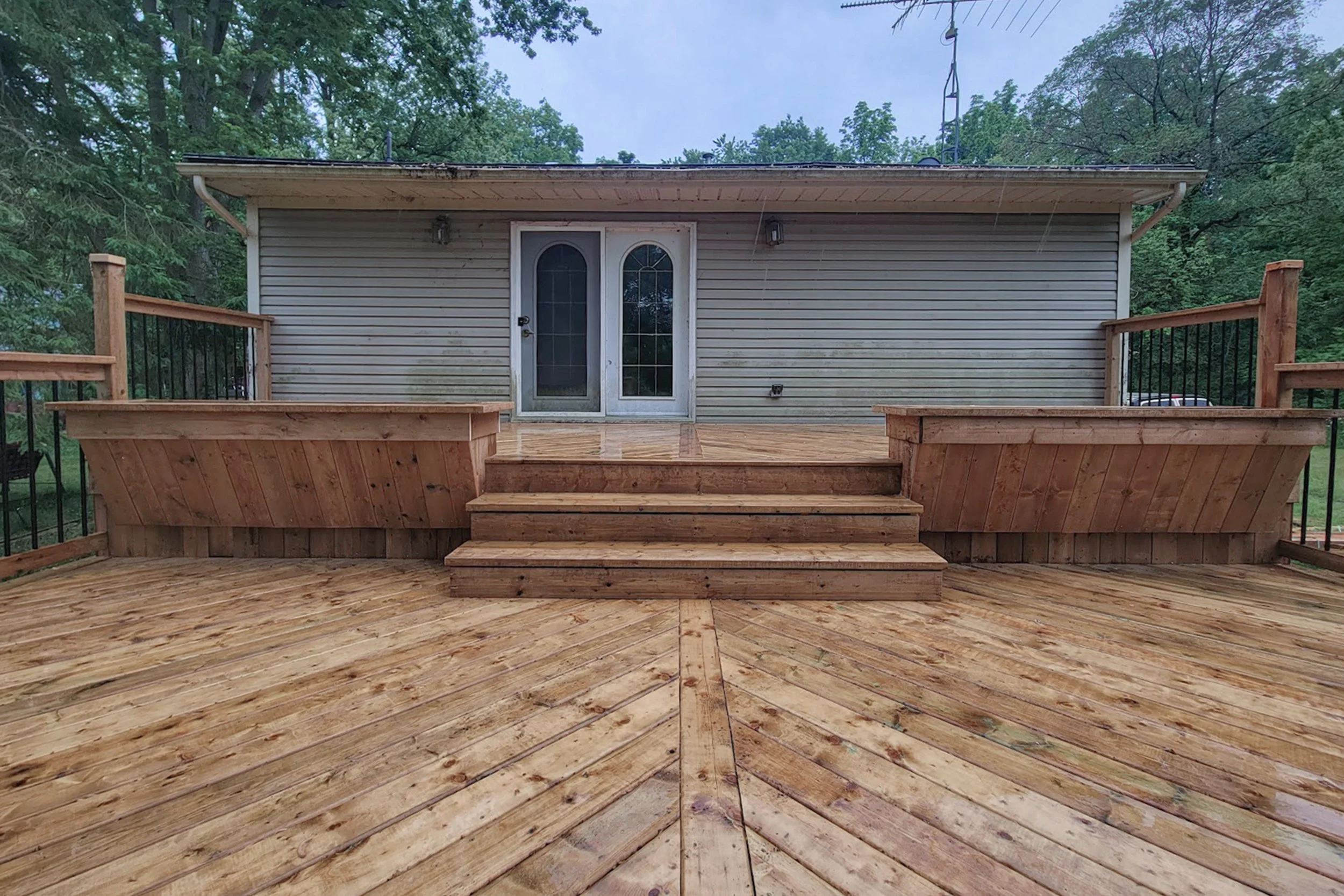 Wood deck with full-width built-in bench and central staircase.