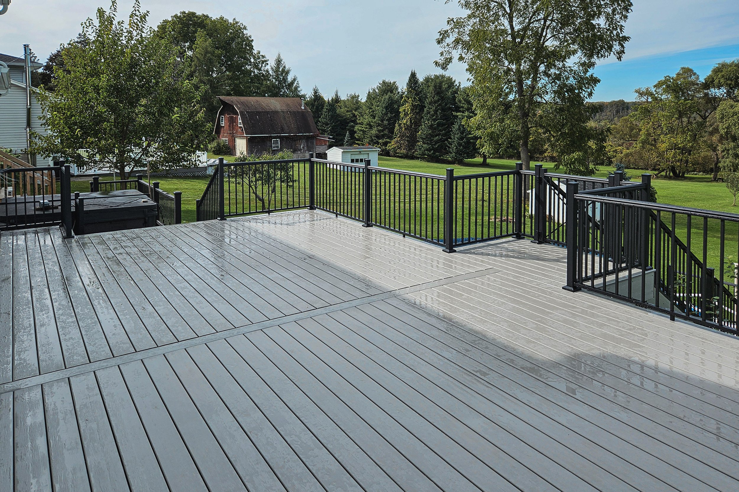Gray composite deck with black aluminum railing.