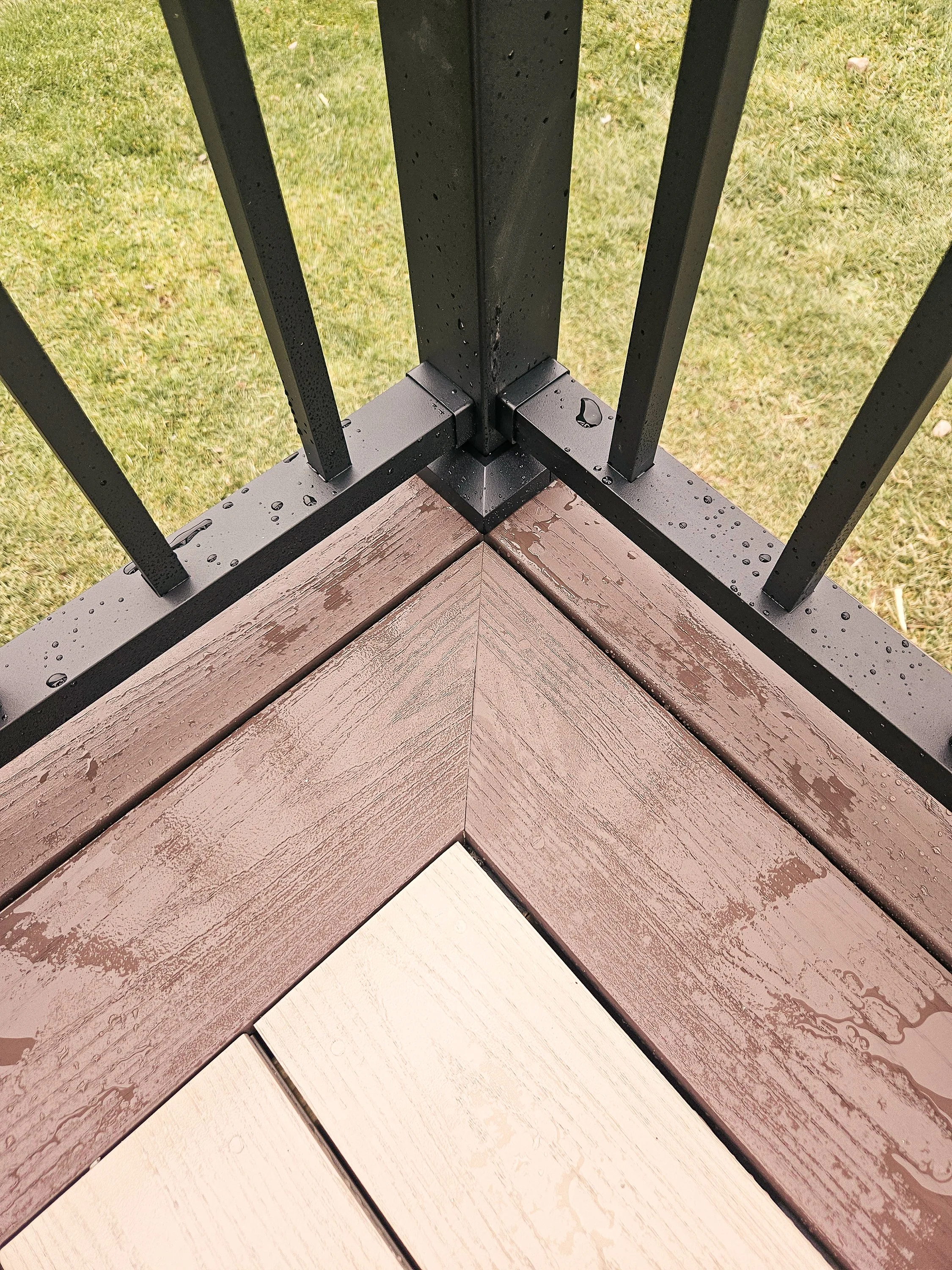 PVC deck corner miter detail with Brownstone border and black railing.