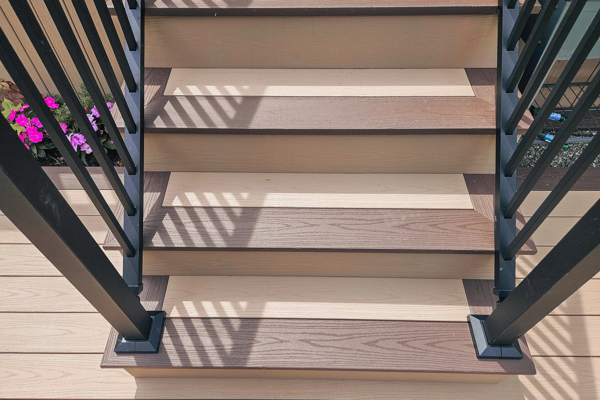 PVC deck stairs with black railing posts and textured treads.