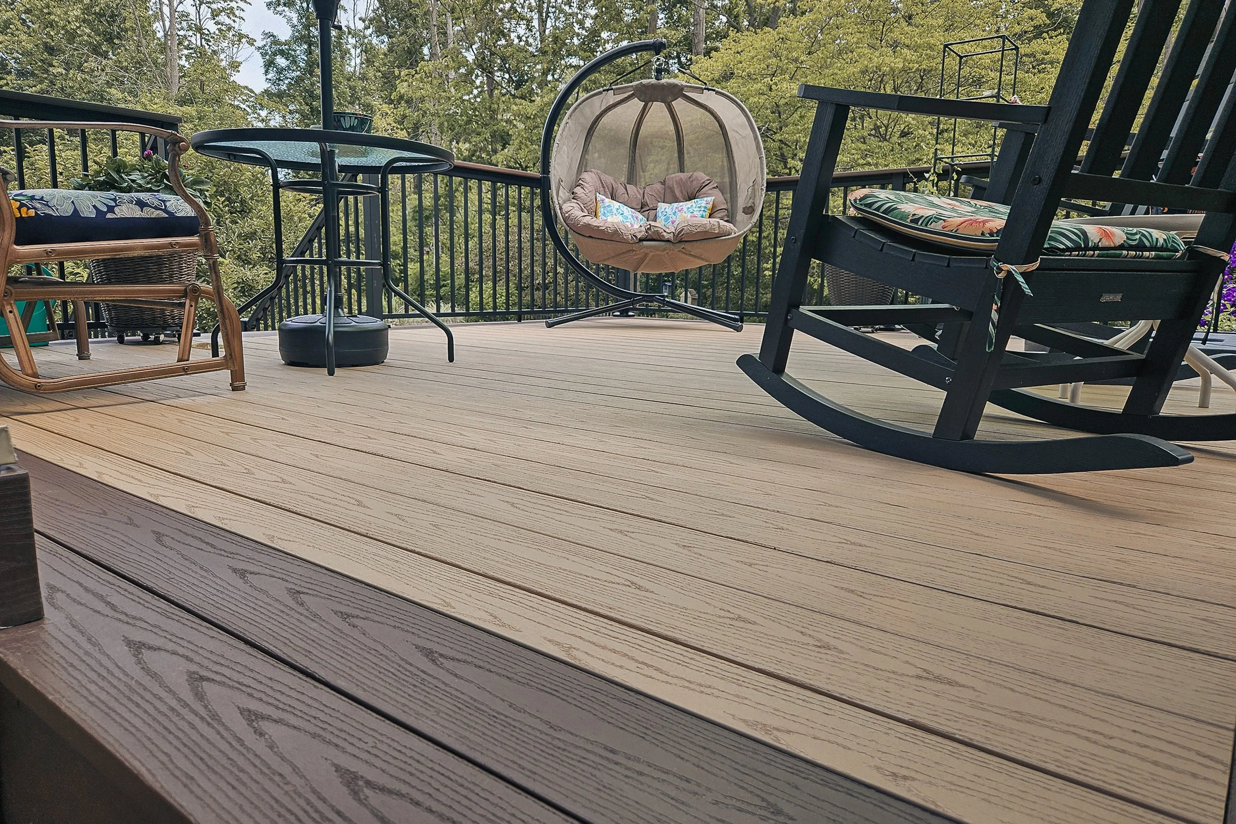 PVC deck surface with outdoor seating and black railing in the background.