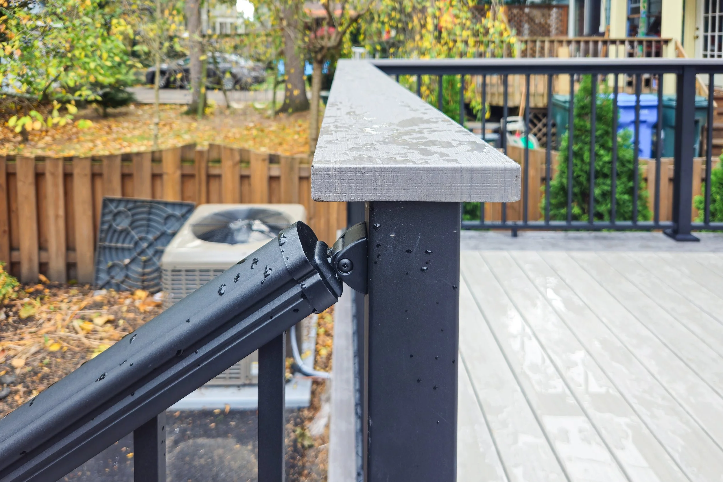Gray deck top rail and black post with railing attachment.