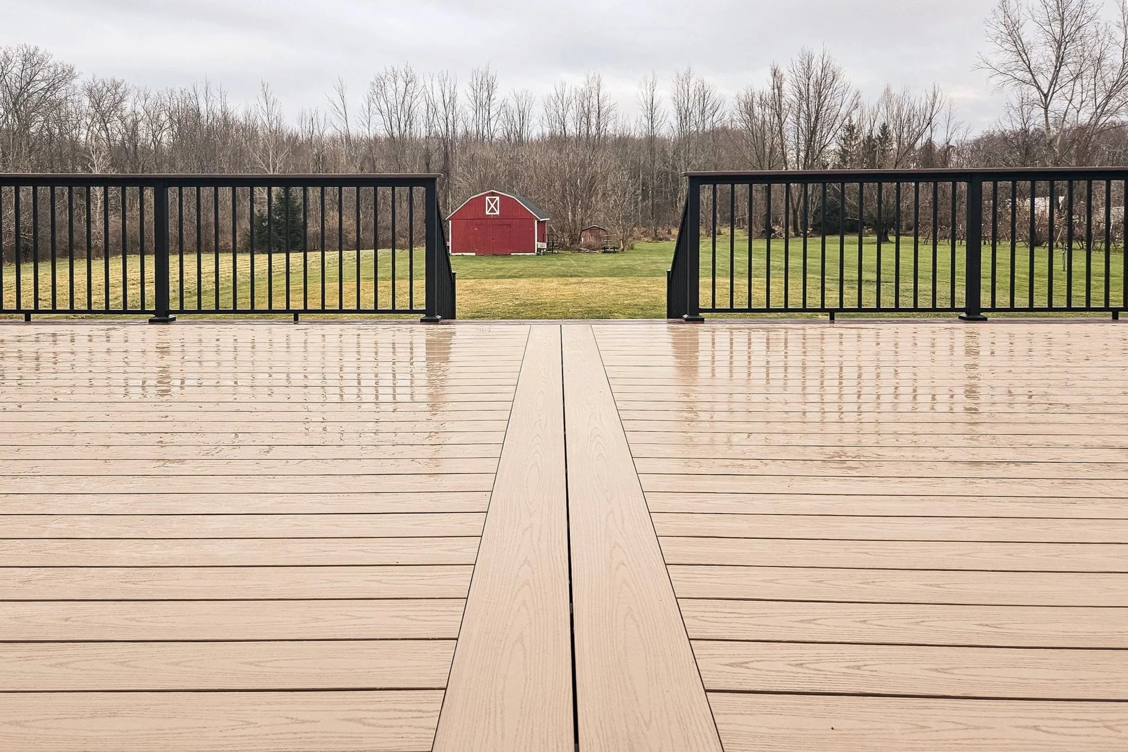PVC deck surface with center board seam and black railing.