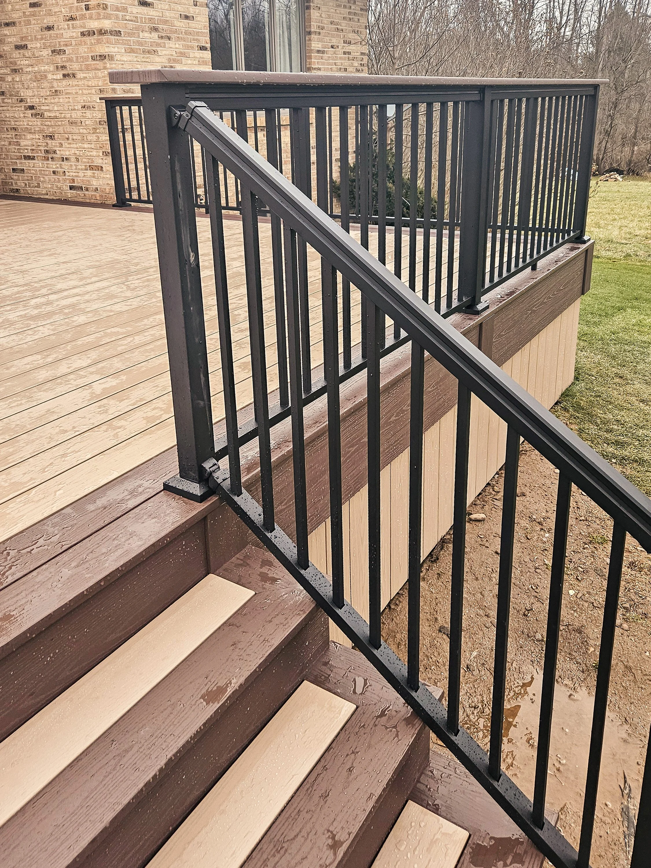 Stair railing and PVC deck steps with Brownstone treads and black balusters.
