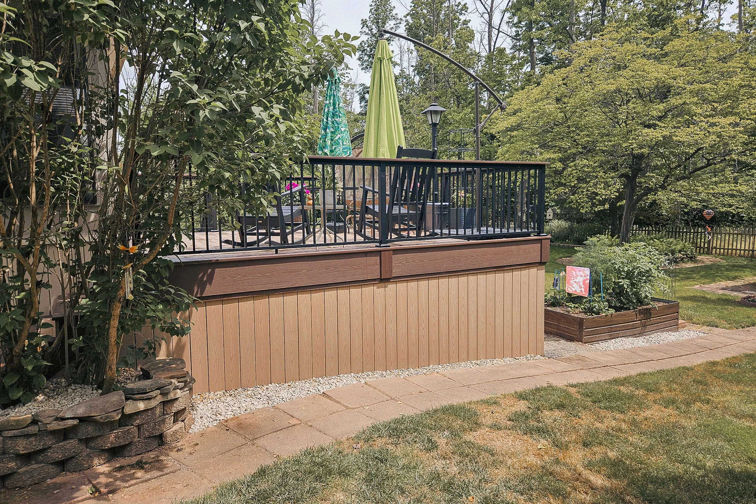Side view of PVC deck with black railing and vertical skirting.