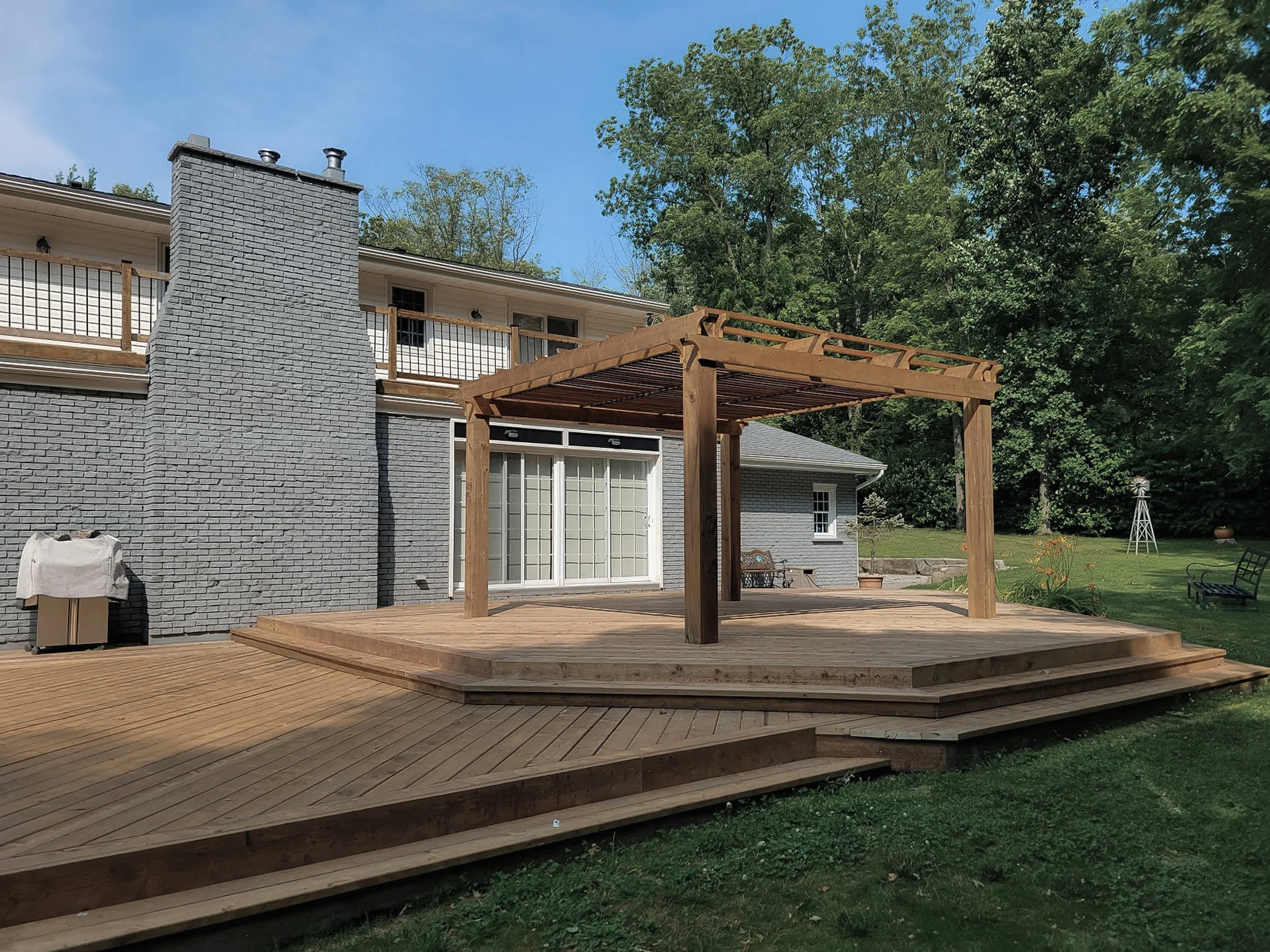 Wood pergola on a raised deck with open beam roof