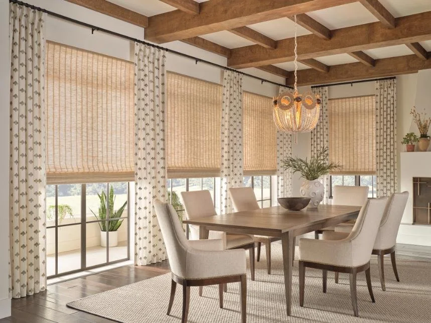 Elegant dining room with woven Roman shades and patterned drapery, showcasing custom window blinds, shades, and shutters Pittsford, NY for stylish light control and privacy.