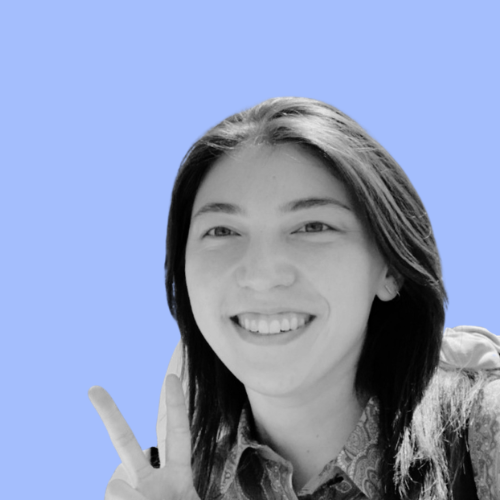 Young woman smiling and holding up two fingers in a peace sign, black and white photo with blue background.