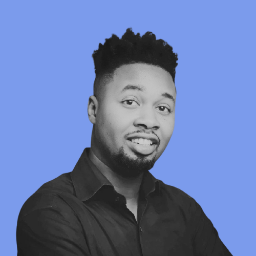 Portrait of a man with black curly hair and a goatee, wearing a black shirt, against a blue background.