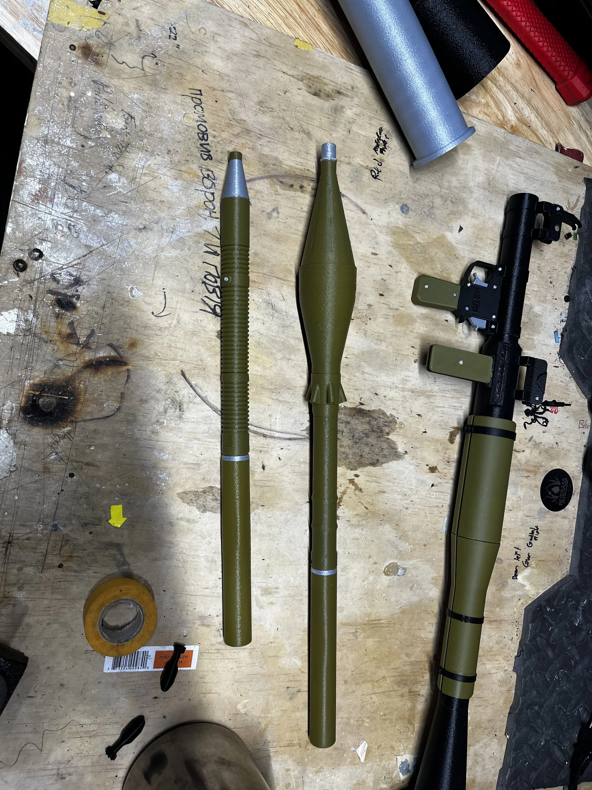 Three rocket-propelled grenades (RPGs) and a rocket launcher on a workbench.
