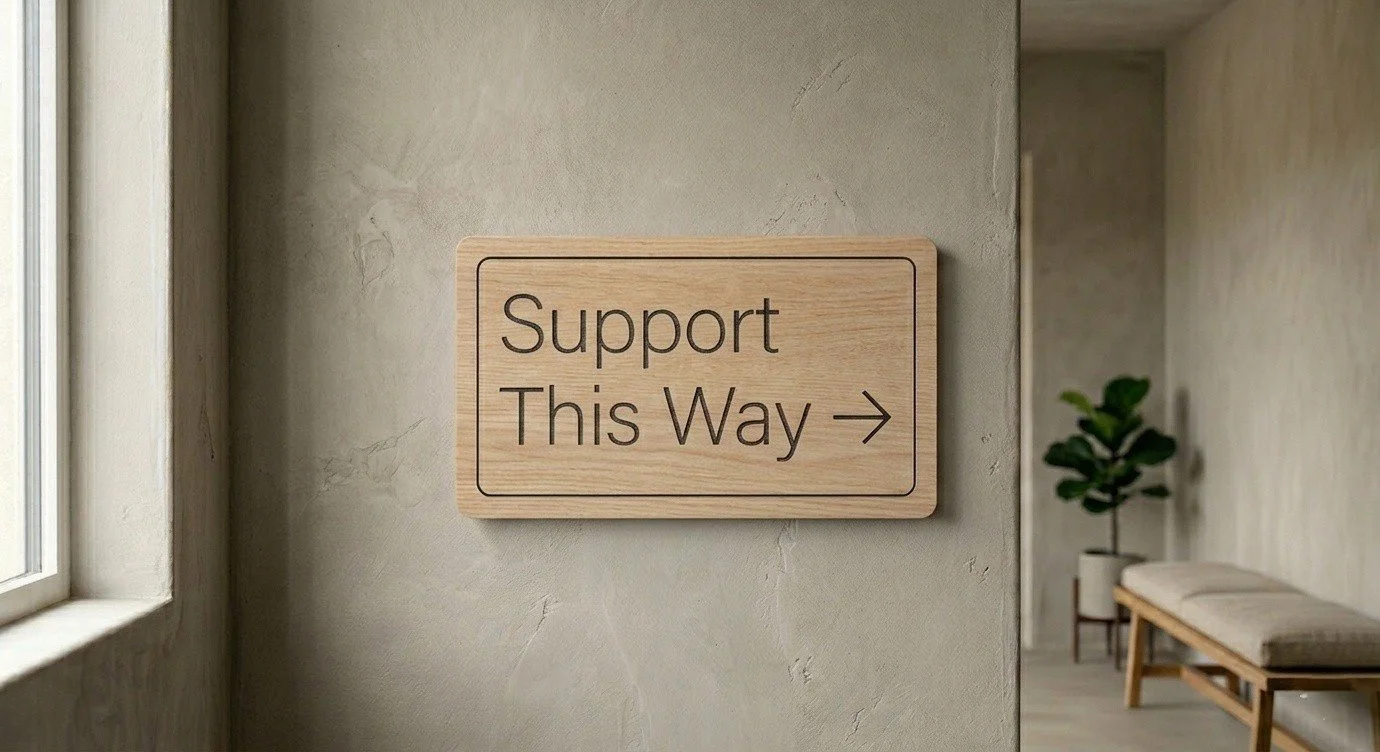 Wooden support this way sign in a calm therapy office hallway representing how to know if therapy could help in Alberta