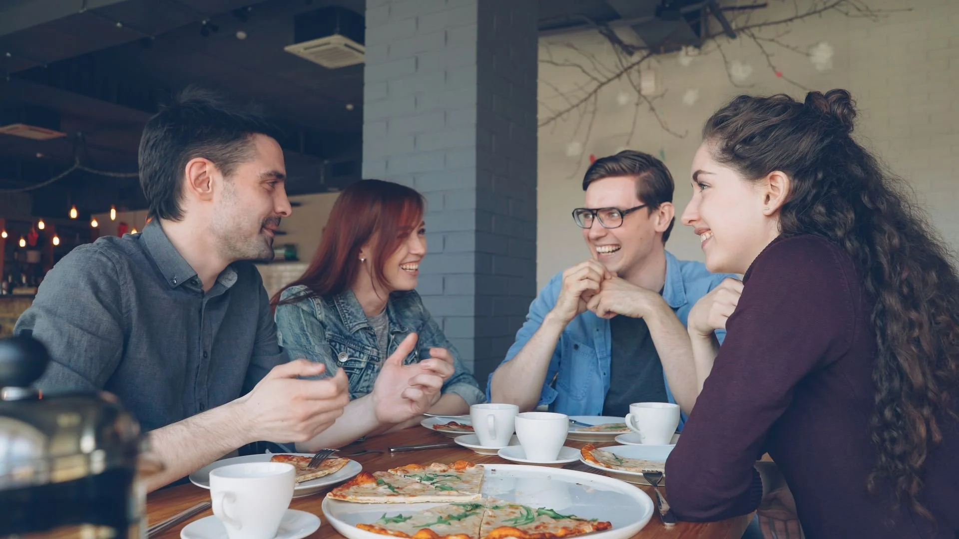 Adults talking together at a café, representing friendship, social connection, and counselling support for adults in Alberta.