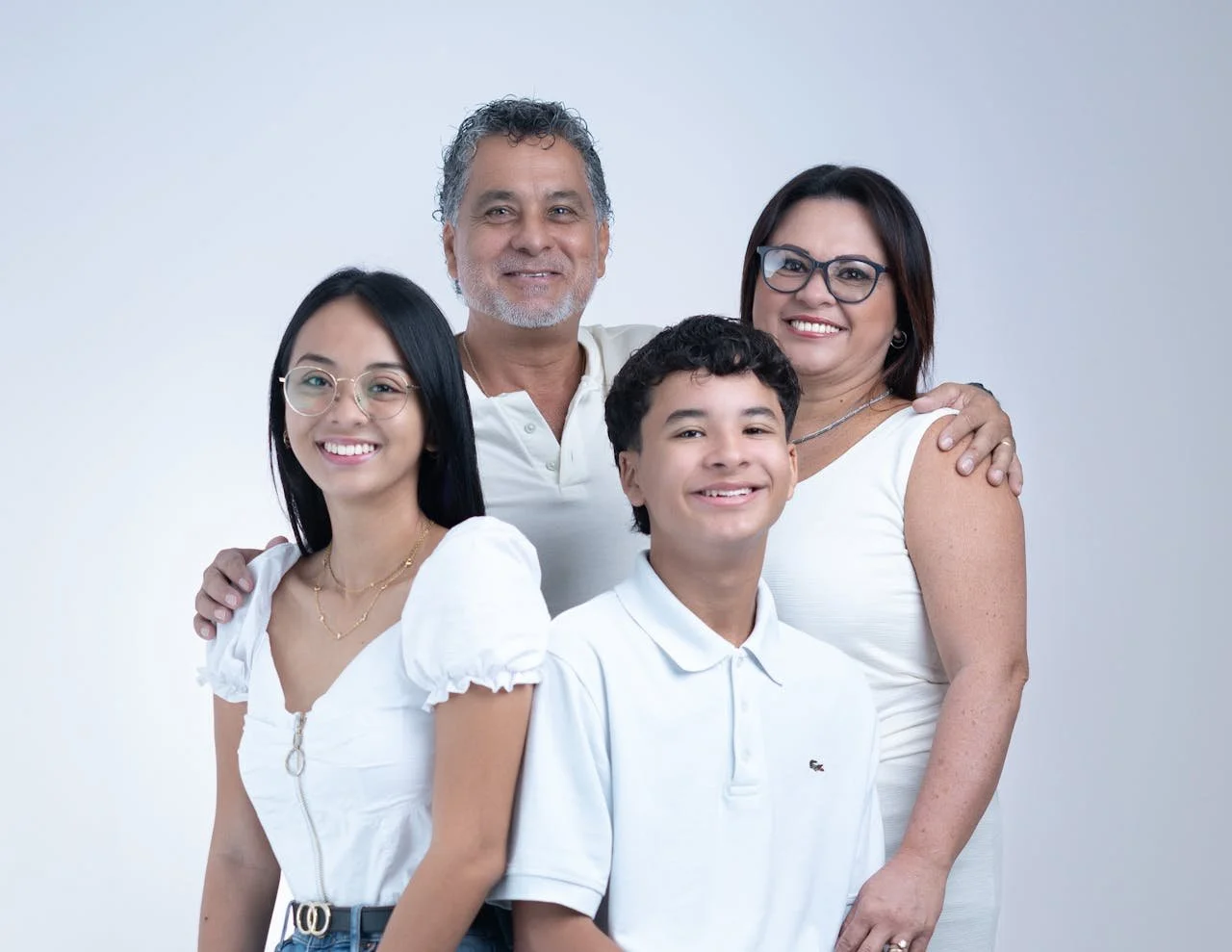 Parents and two children smiling together, representing professional family therapy available across Alberta.