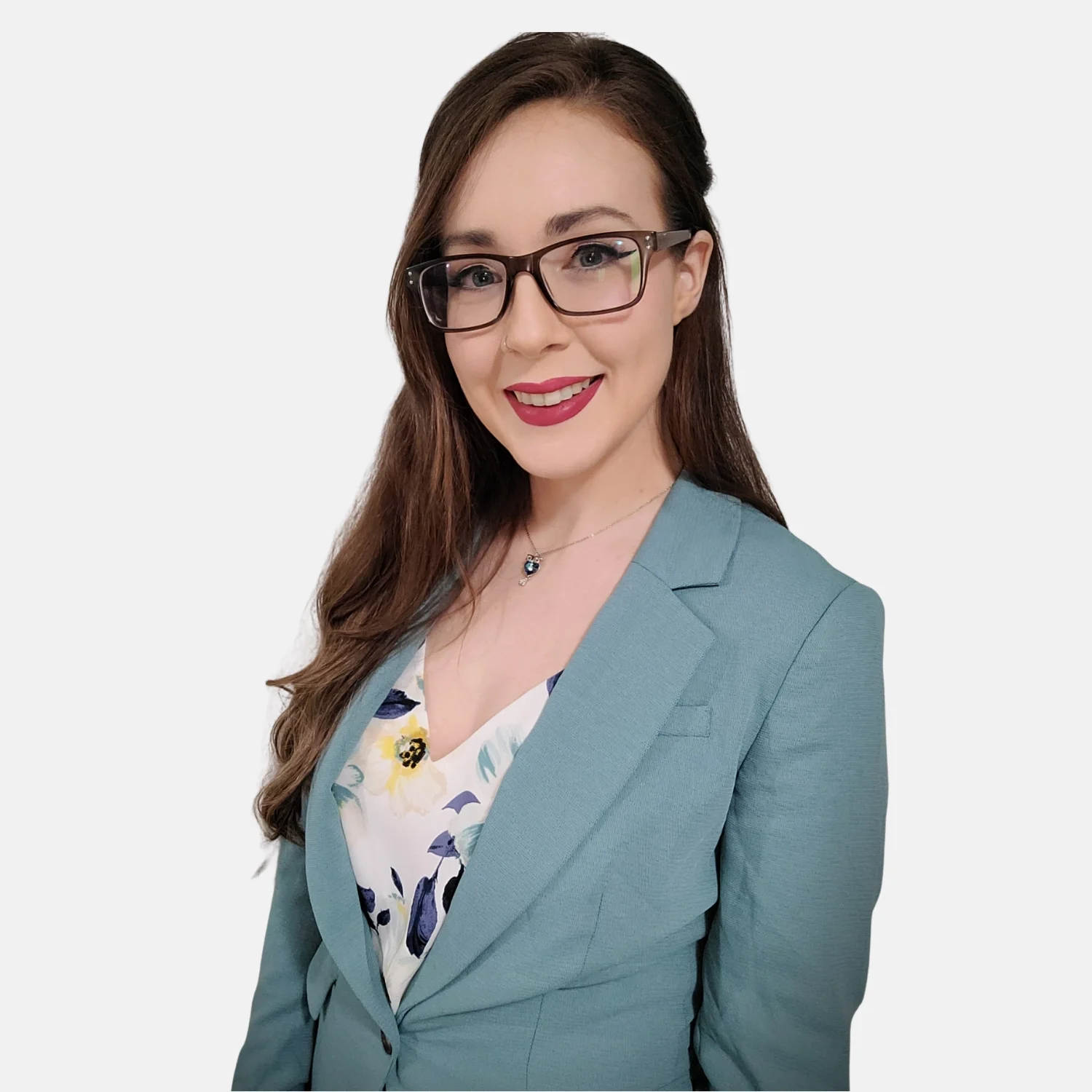 Therapist Samantha's headshot. Image of a woman with long brown hair, glasses, and red lipstick smiling, wearing a light blue blazer and a floral blouse against a plain gray background.