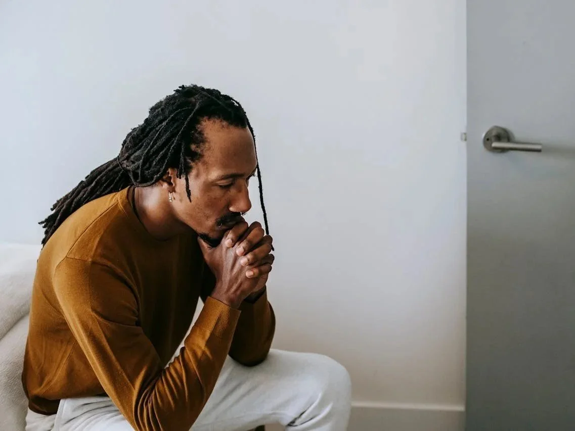 Man sitting quietly and processing grief during a difficult period, representing grief counselling support in Alberta.