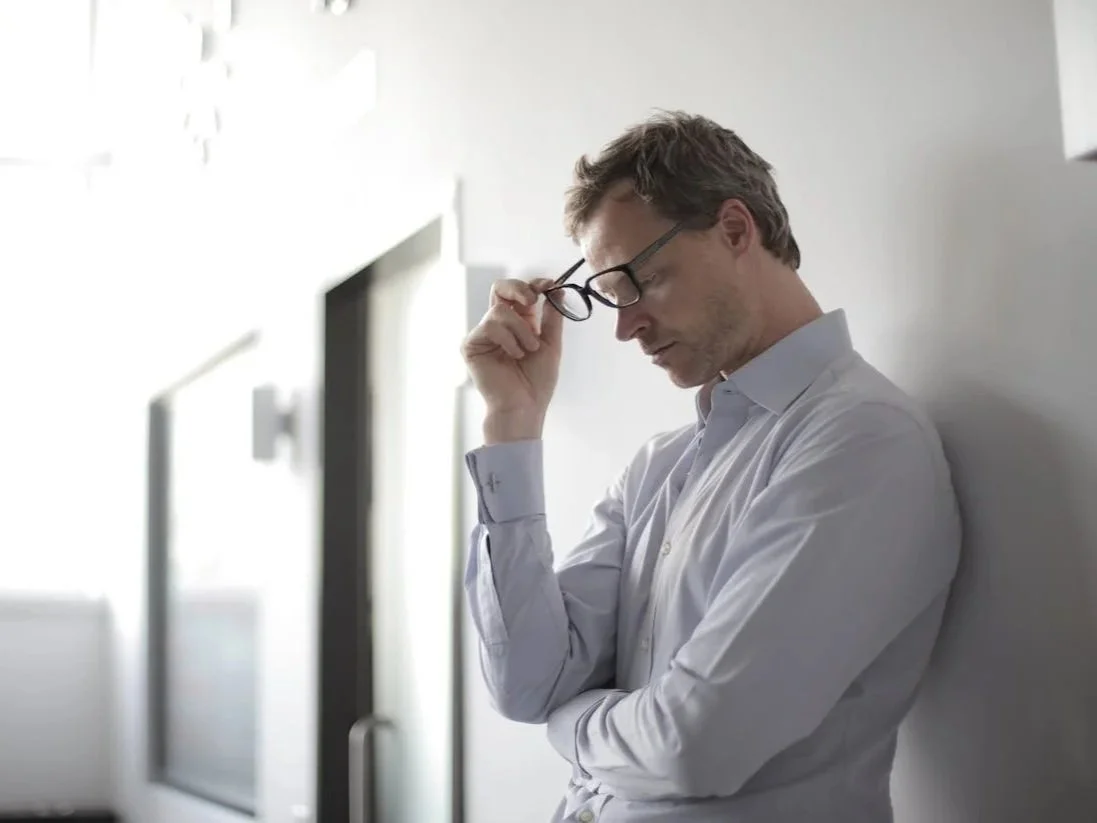 Man standing near a window with a tense posture, representing anger management counselling services in Alberta.