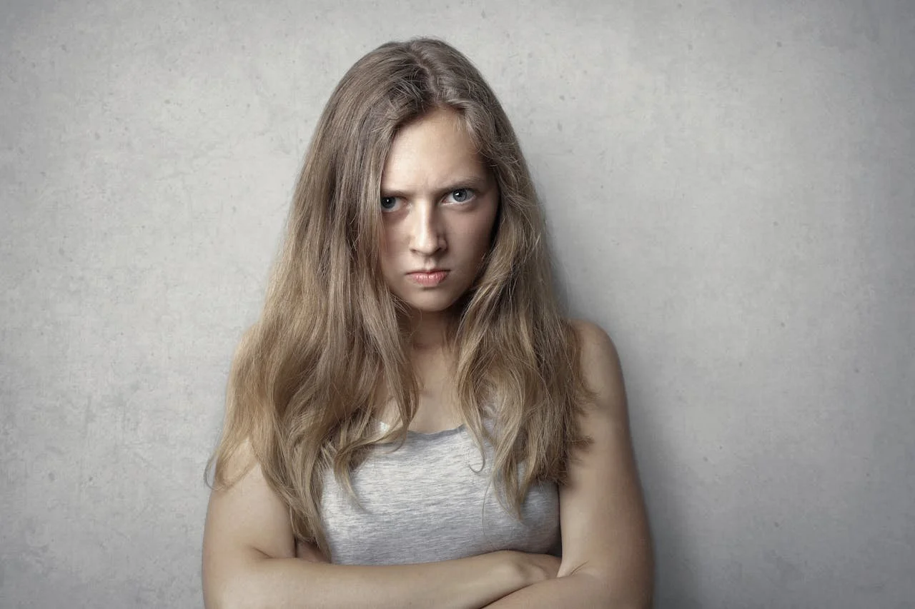 Female with her arms crossed with an angry expression