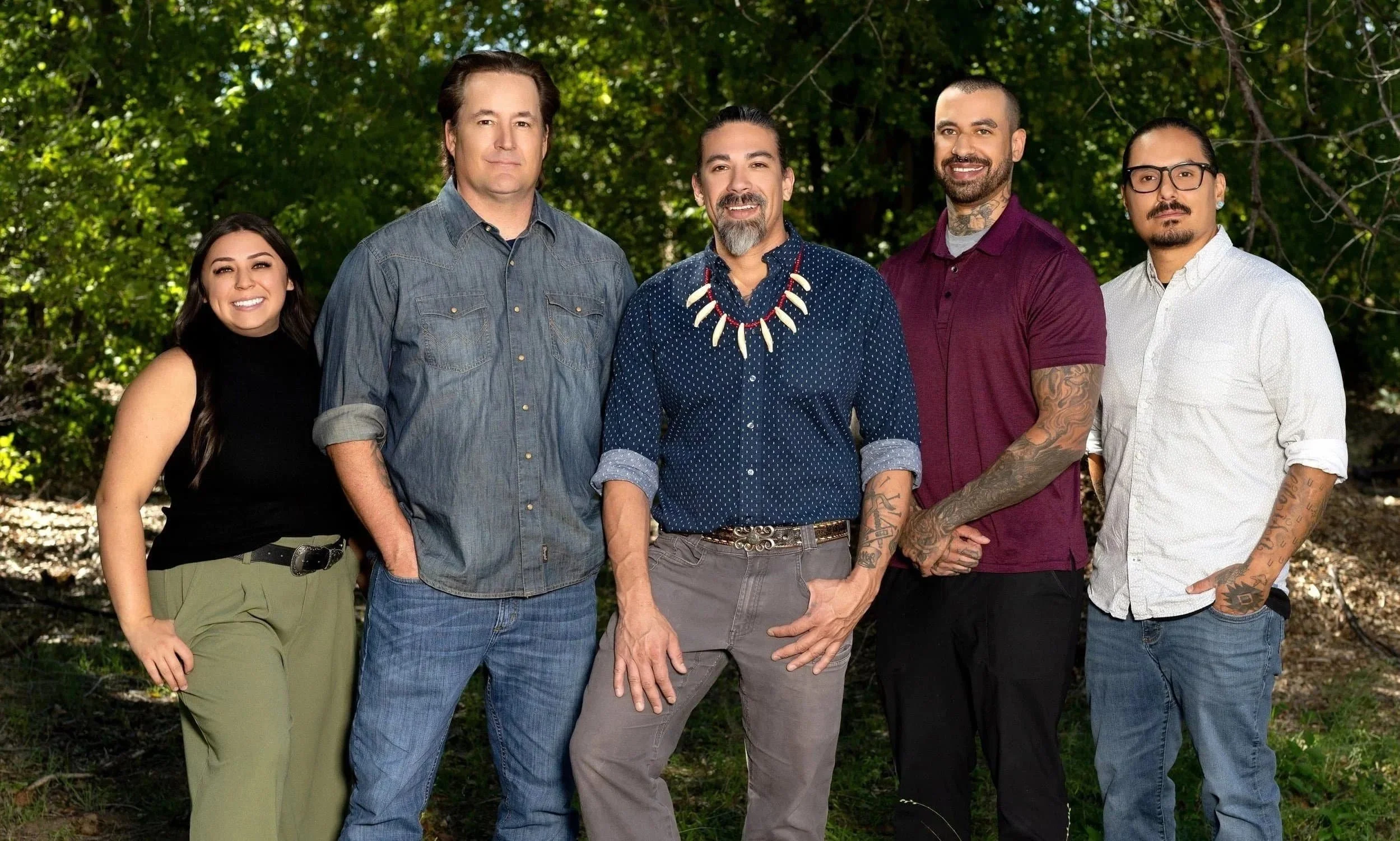 A group of five diverse people who are posing for a professional photo.