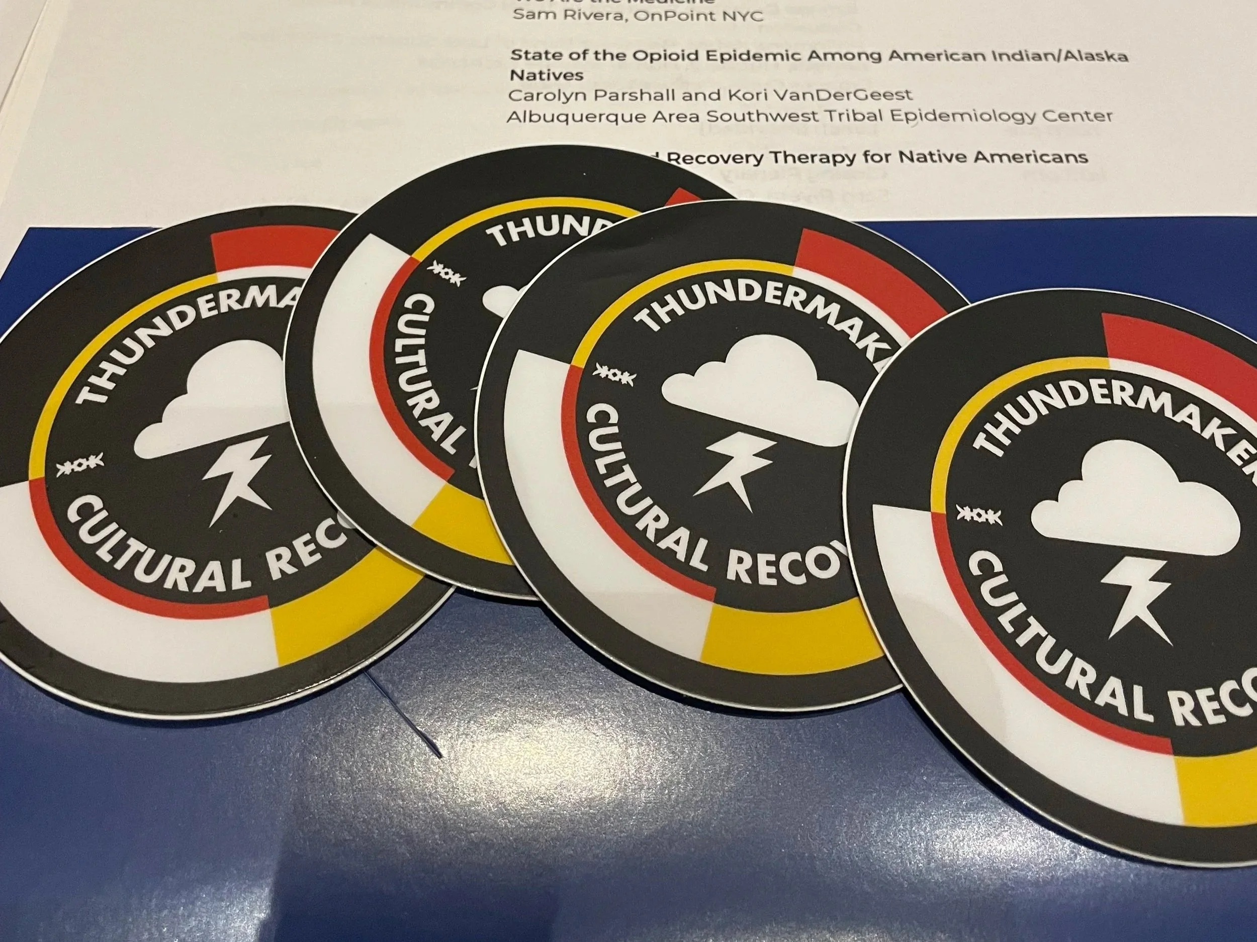 Four circular stickers with the words 'Thundermaker Cultural Recovery' surrounding an icon of a cloud with lightning, colored in black, red, yellow, and white