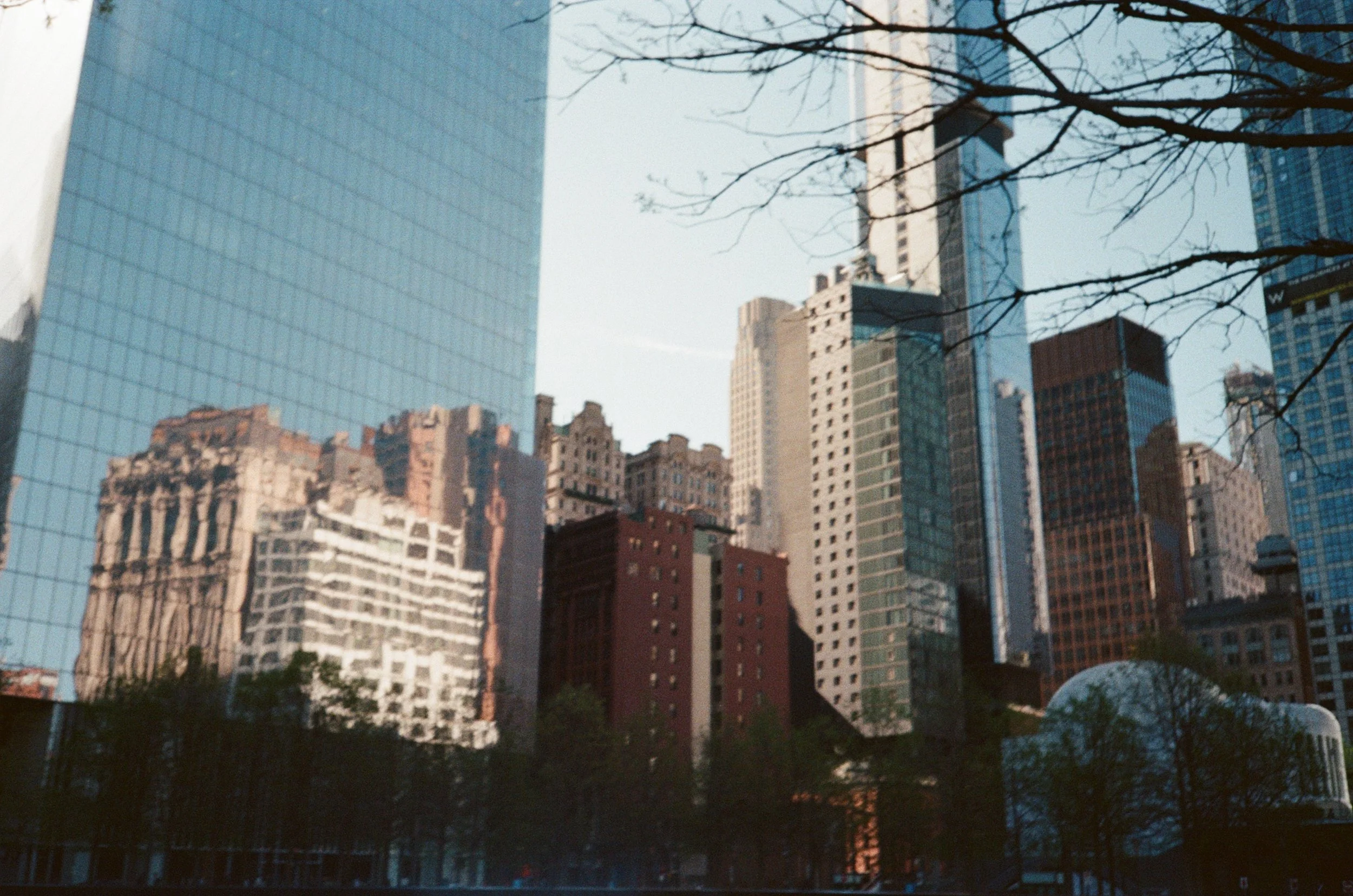 Riflesso di grattacieli e edifici in un'alta finestra di vetro in un quartiere urbano.