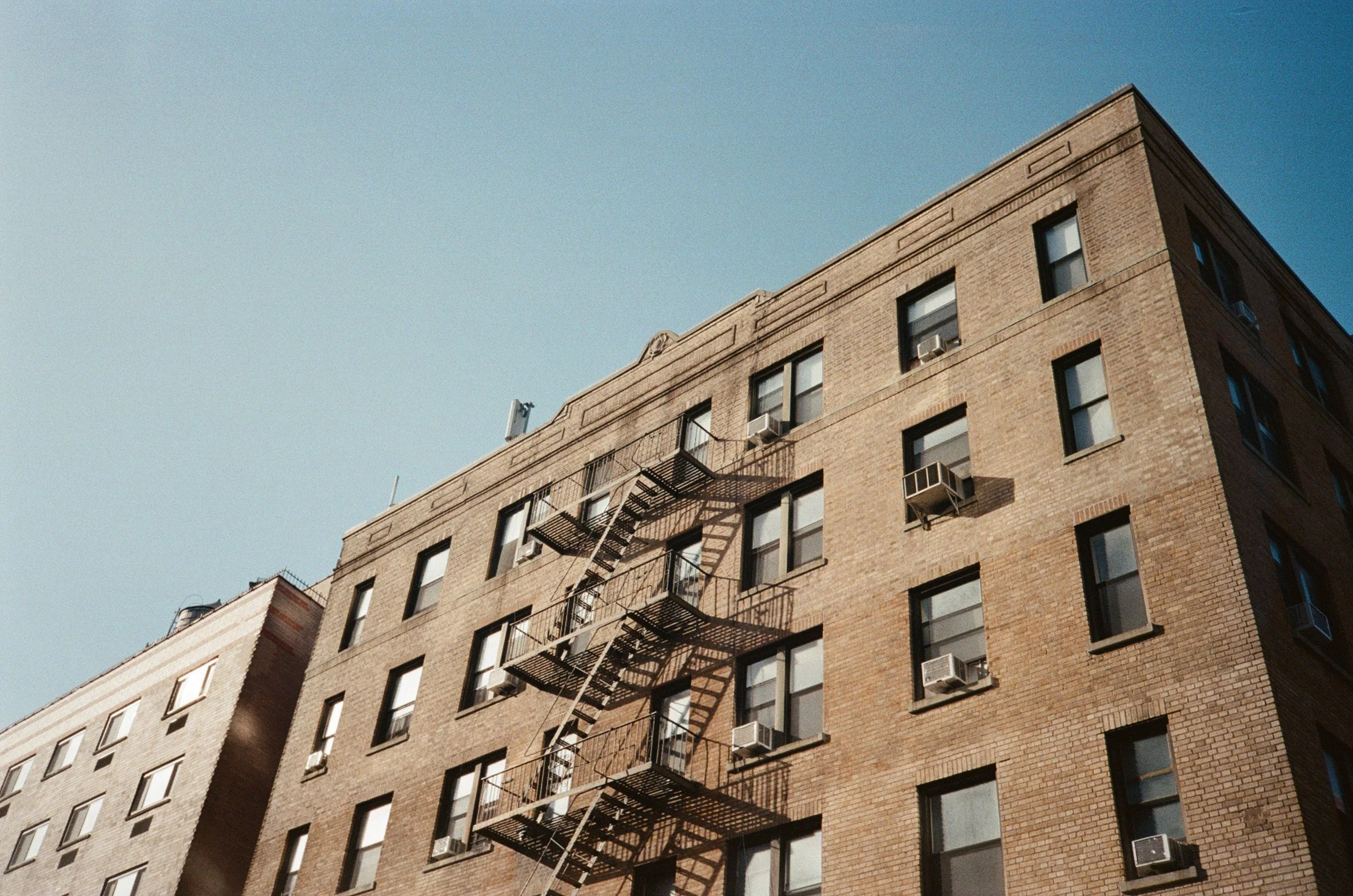 Edificio residenziale in mattoni con finestre e condizionatori, vista dall'angolo.