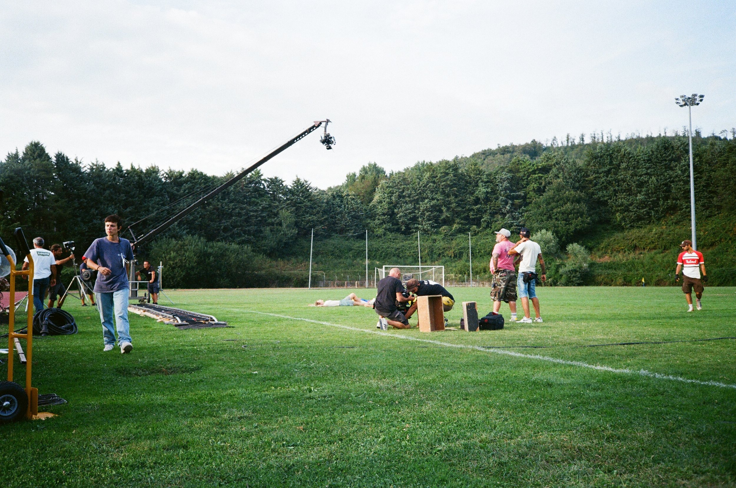 Set di persone su un campo sportivo durante le riprese di una scena.