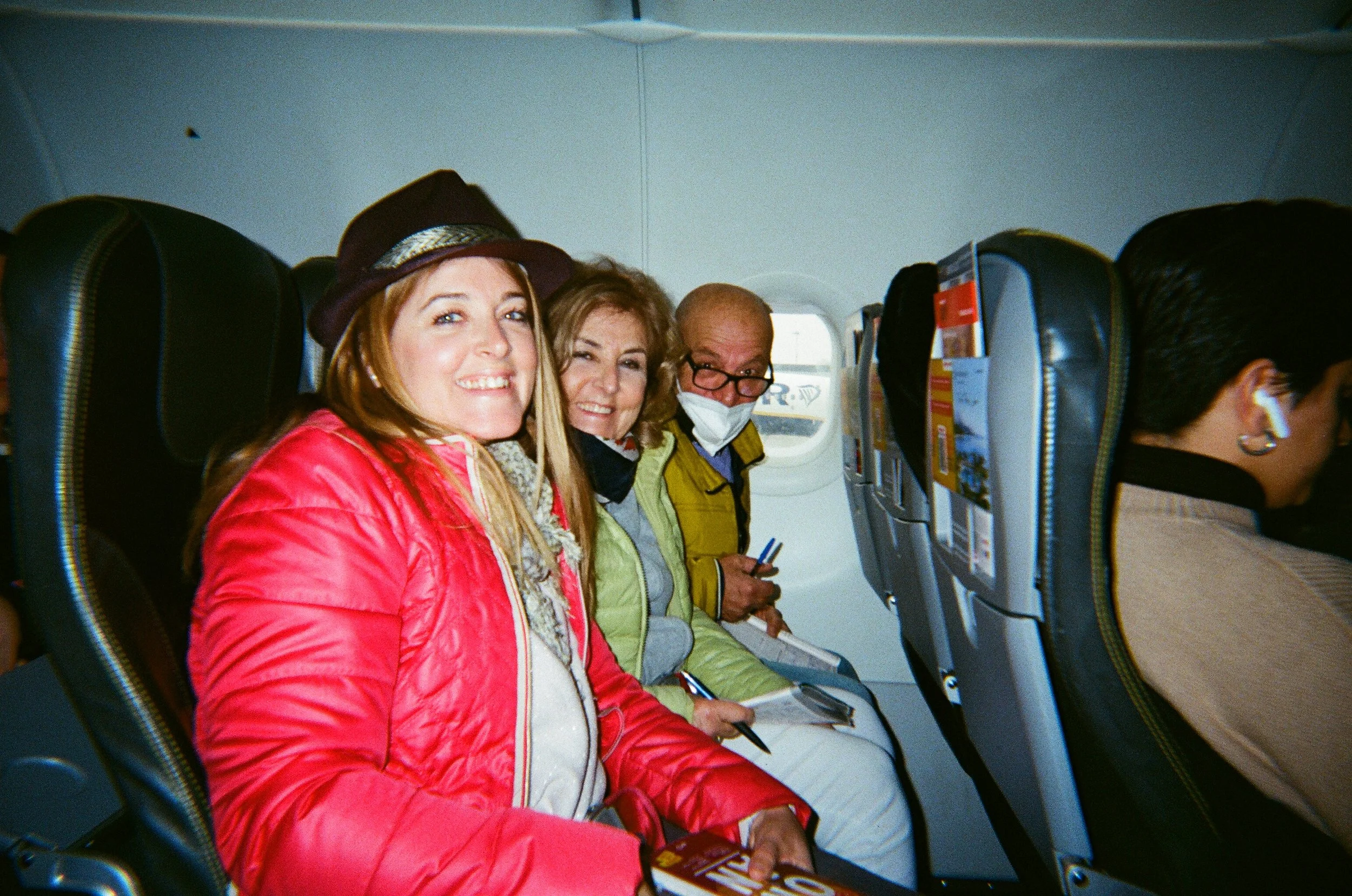 Passeggeri sorridenti seduti su un aereo lungo il finestrino di proprietà