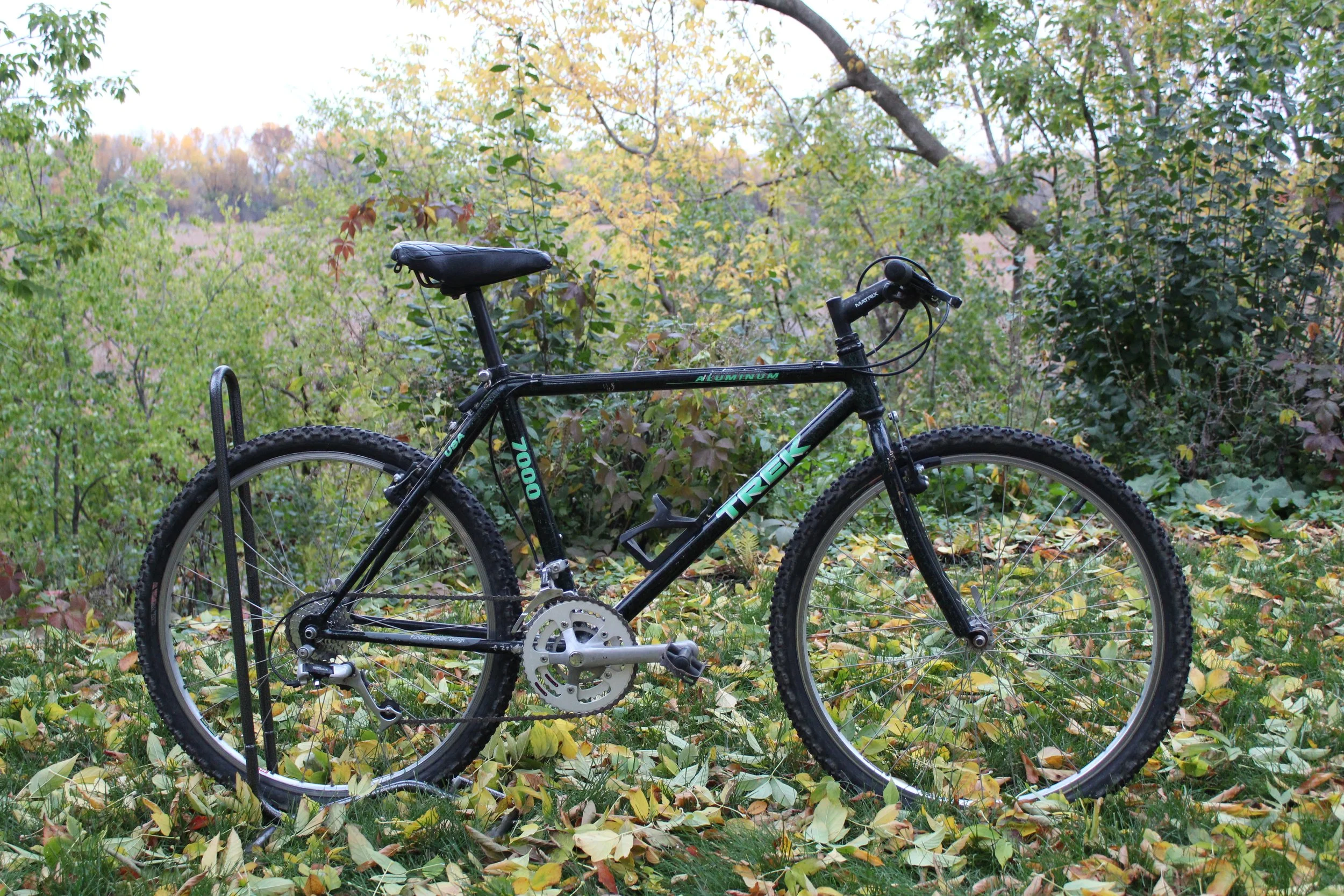 Mountain bike with black frame parked on grass