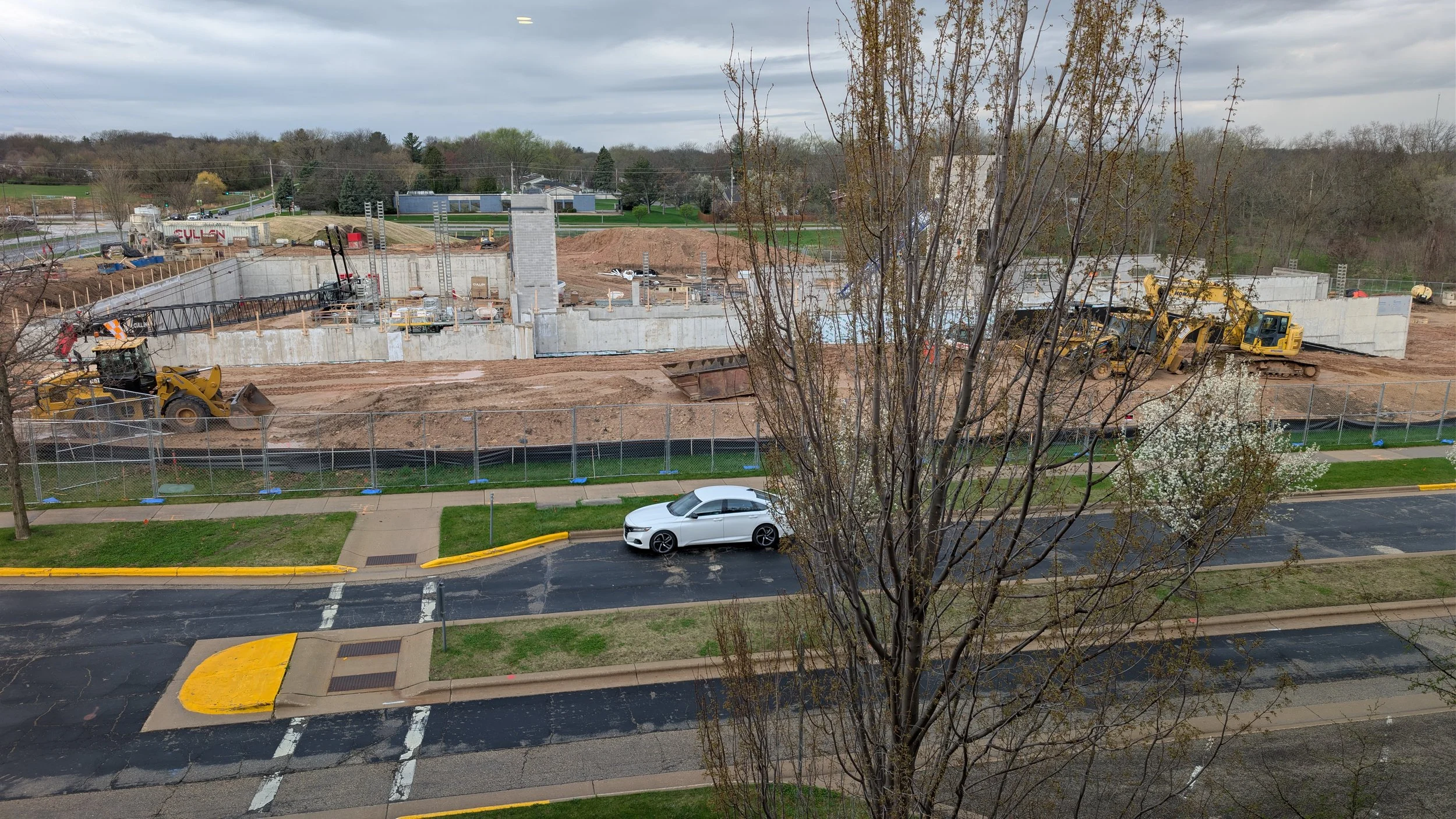 A concrete building foundation rises from the ground