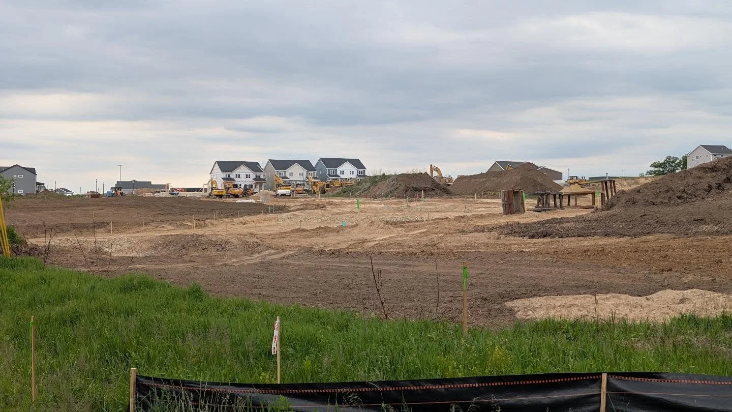Road construction with homes in the background