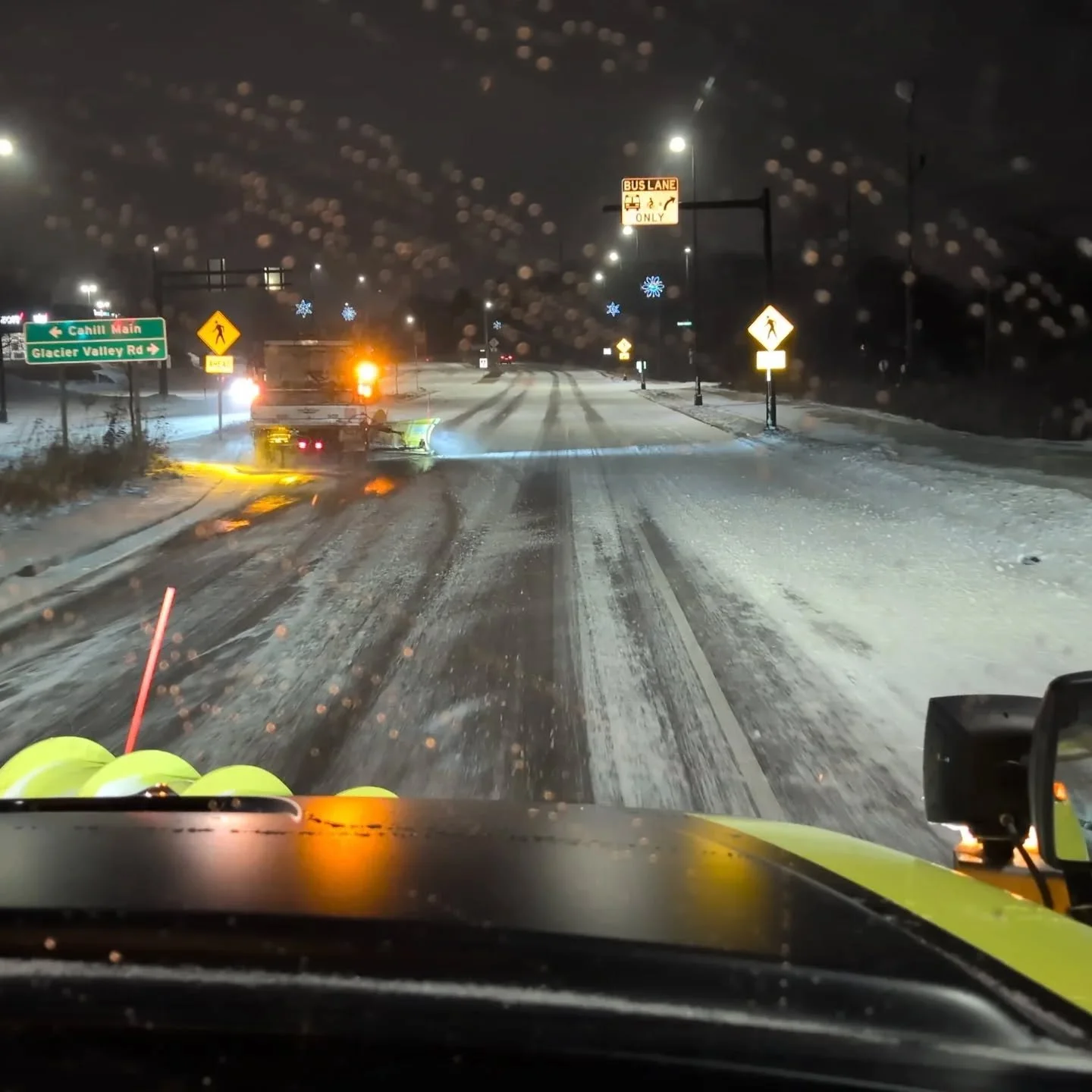 A view of a snowy street from a plow