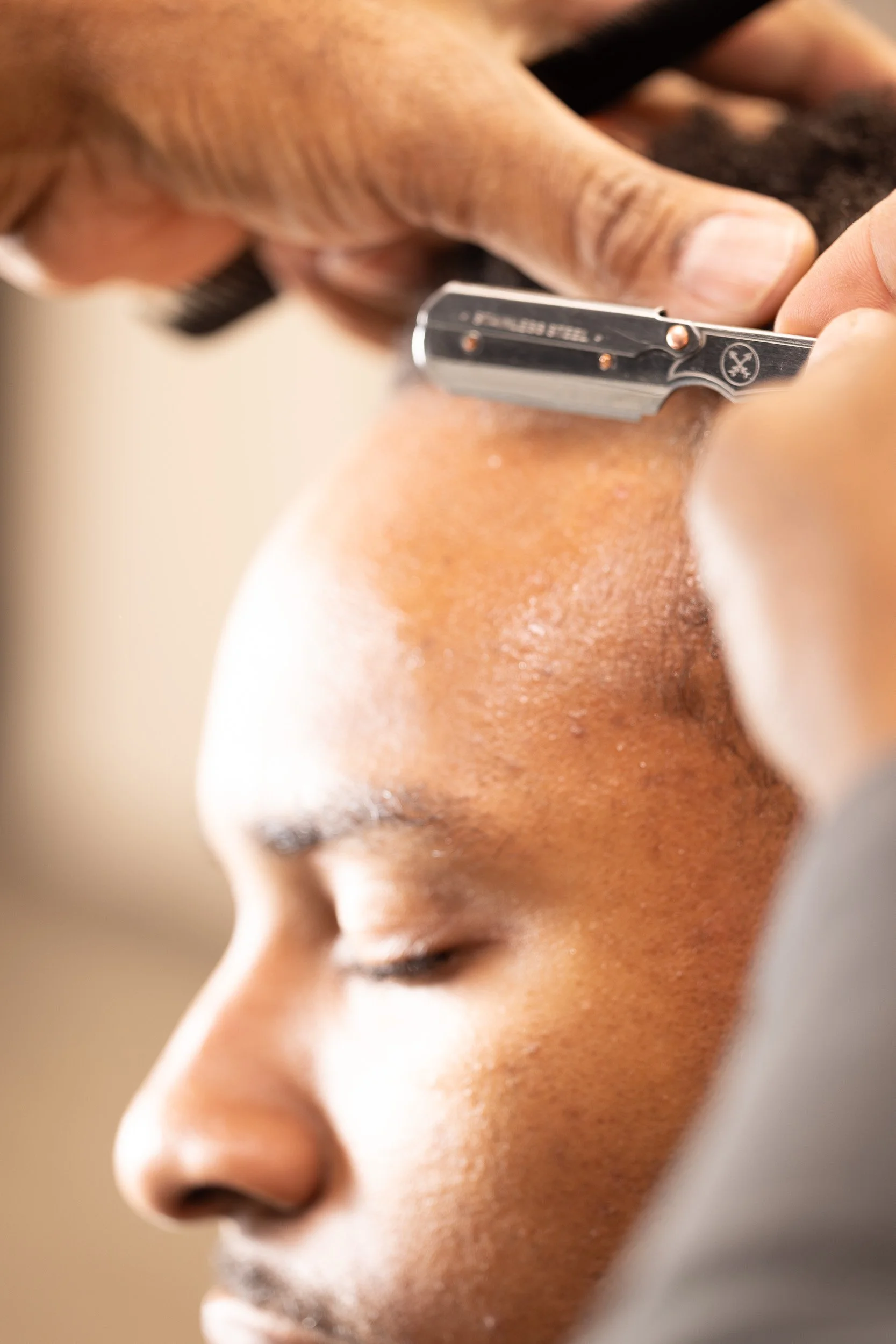 Close-up of a person getting a shave with an electric razor.