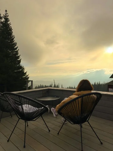 Serene landscape with a person relaxing overlooking view, illustrating the mental and emotional benefits of stillness.