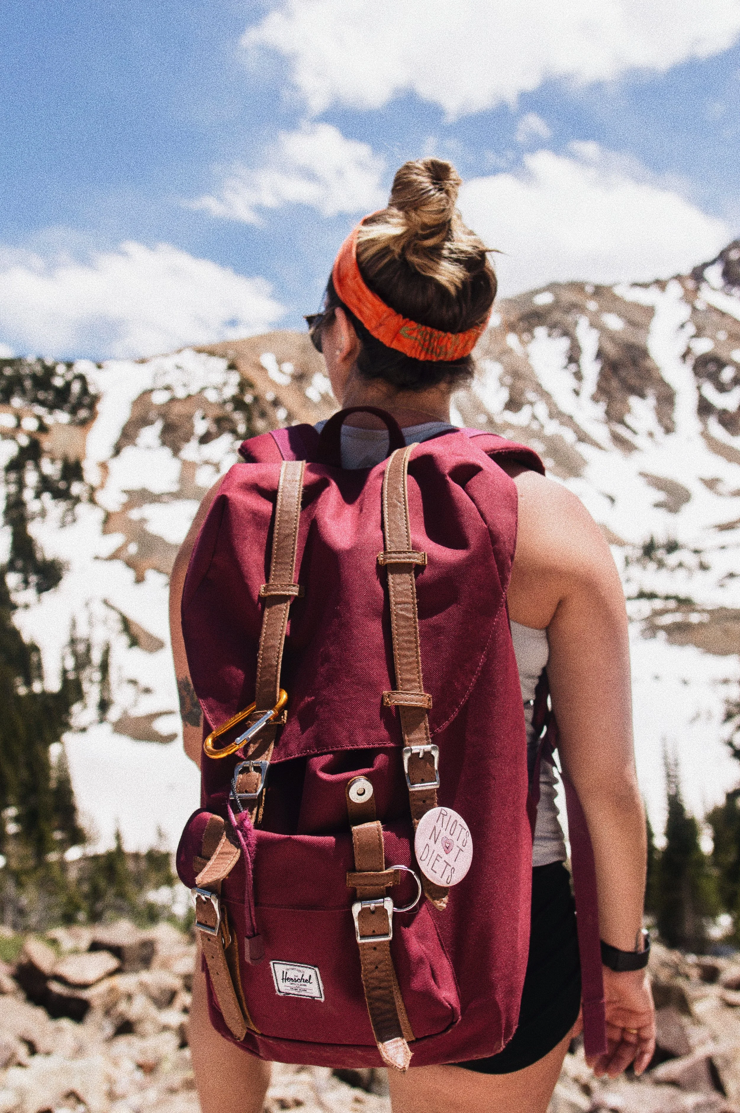 Woman hiking at the base of a mountain beginning her adventure. Represents getting started and beating procrastination.
