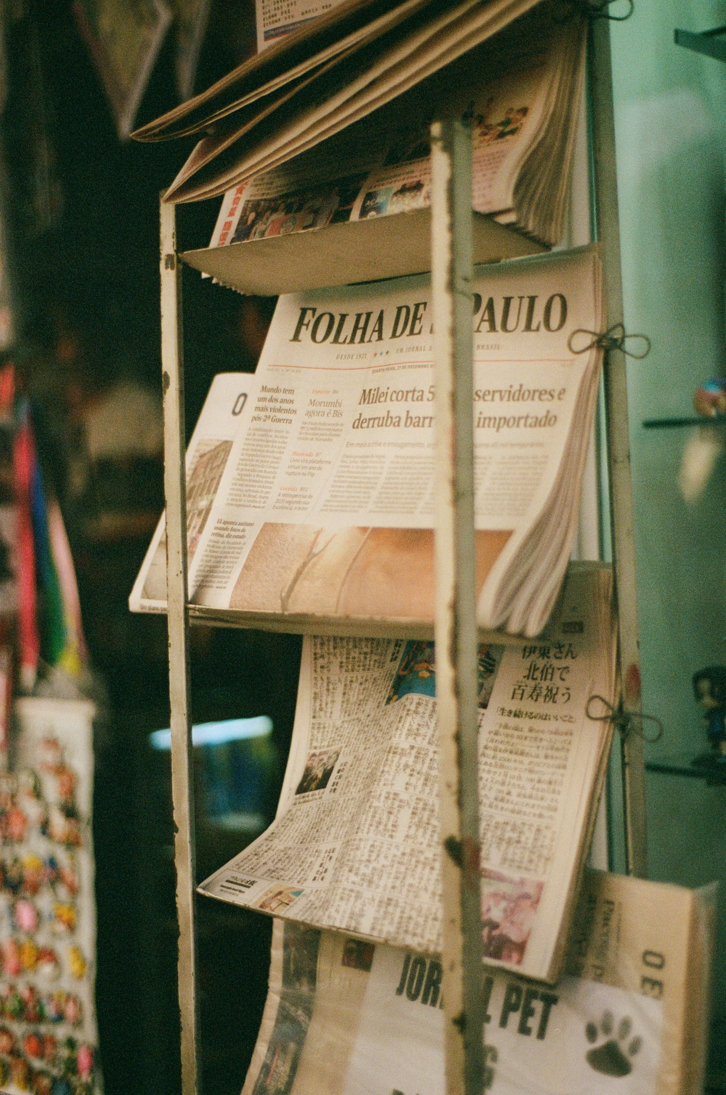 Newspapers and magazines displayed on a newspaper rack.