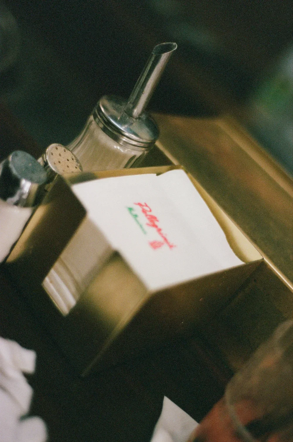 A dipping sauce container with a straw, a salt shaker, a pepper shaker, and a box of Krispy Kreme donuts on a counter.