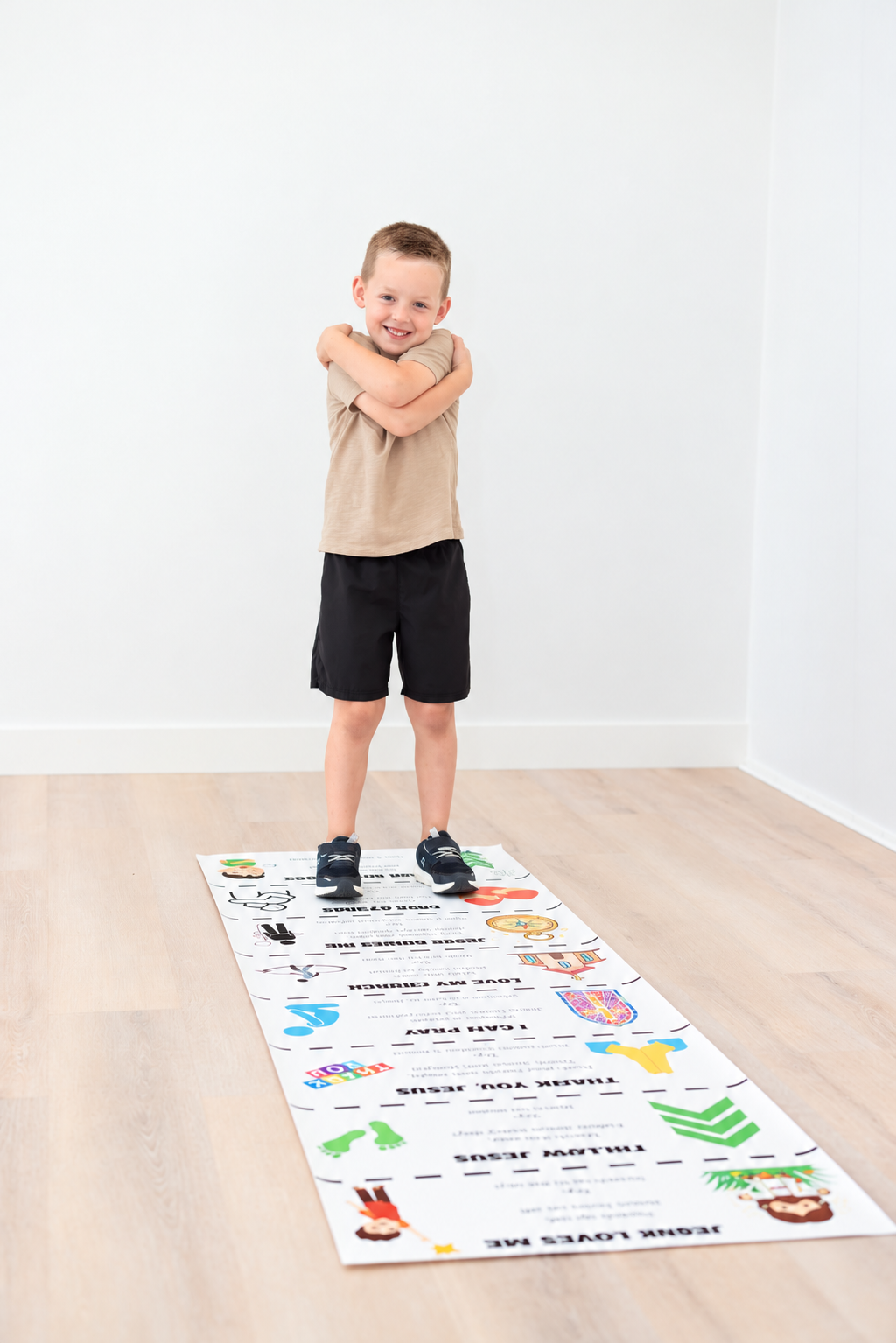 Smiling Boy on a Jesus-Themed Activity Mat.png